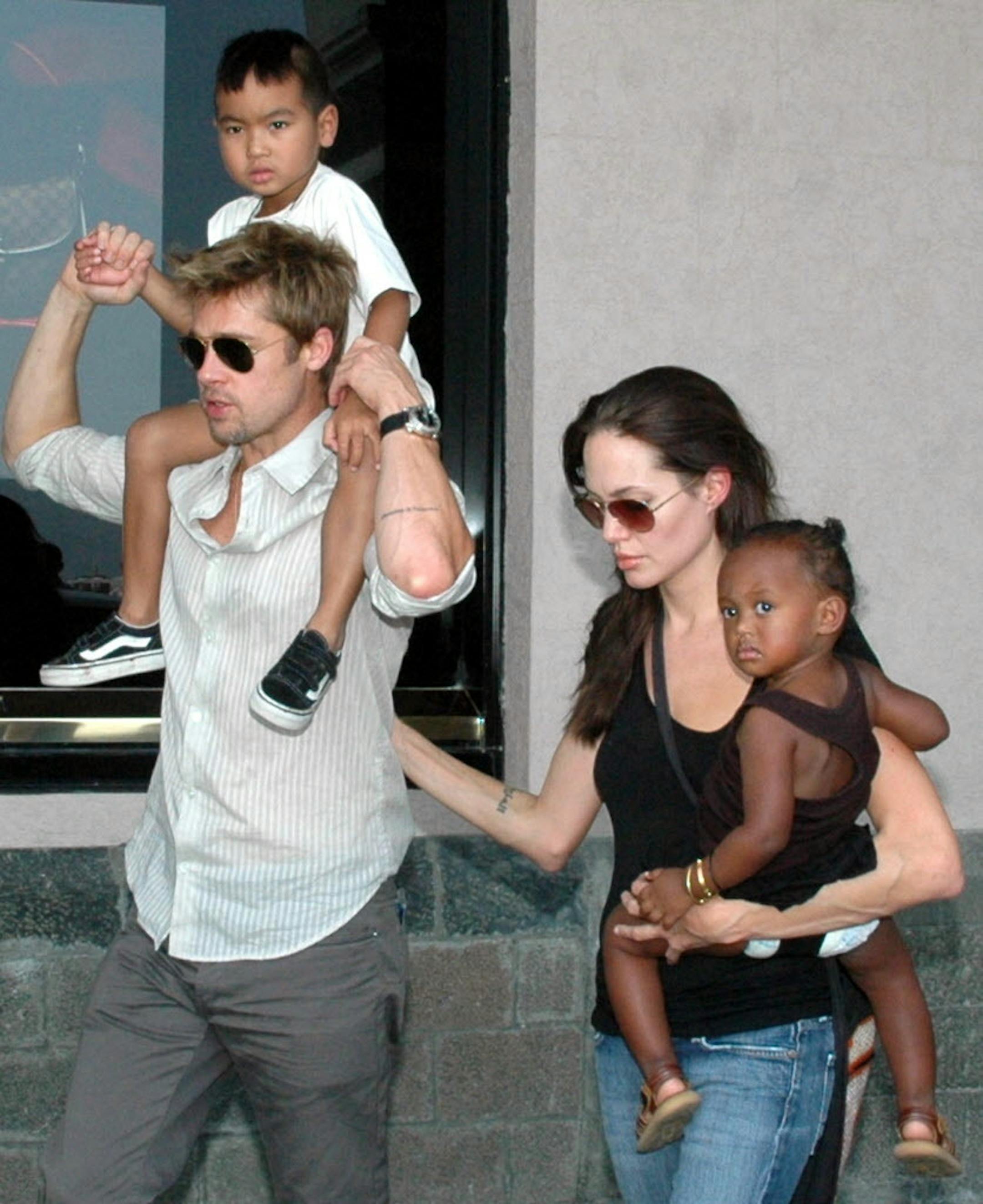 In 2006, American movie star and UNHCR Ambassador Angelina Jolie with her daughter Zahara, and Brad Pitt, left, with Jolie's son Maddox, walk near the Gateway of India in Mumbai, India.