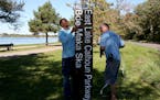 Minneapolis Park and Recreation employees Dan Falk, left, and Tim Coffin prepared one of several new signs installed Friday around Lake Calhoun in Min