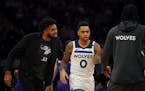 An injured Minnesota Timberwolves center Karl-Anthony Towns had encouraging words for Minnesota Timberwolves guard D'Angelo Russell (0) at a first qua