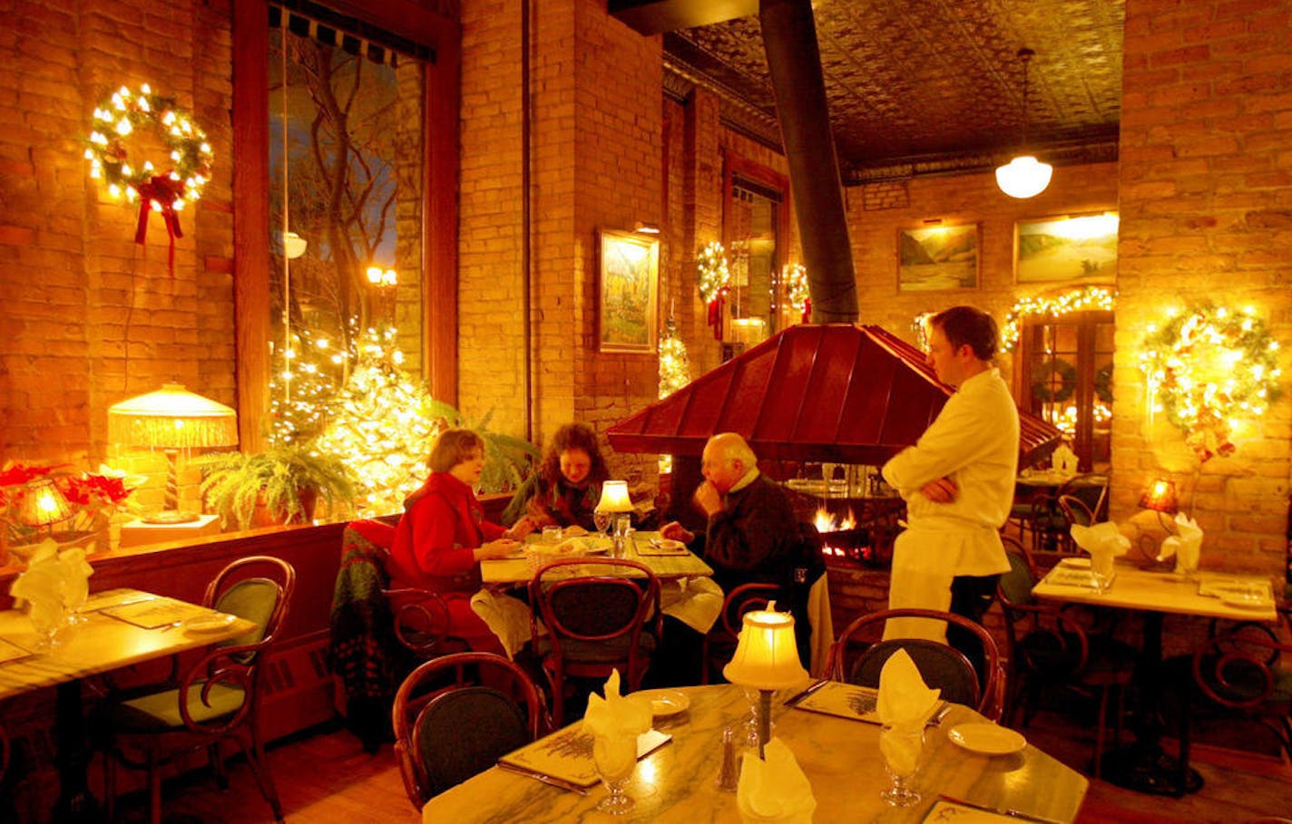 Sitting by the copper-topped fireplace, From left, Donarae Peterson, Heidi Geimer and Bob Peterson, one of the coziests places in the dining rooms at W.A. Frost, 374 Selby Av., St. Paul, The three found it a perfect place for a dinner after sending daughter/grandaughter, Hannah Geimer, not pictured, off to France to study for a 7 months. Exeutive chef, Russell Klein, talks about the food with the family.