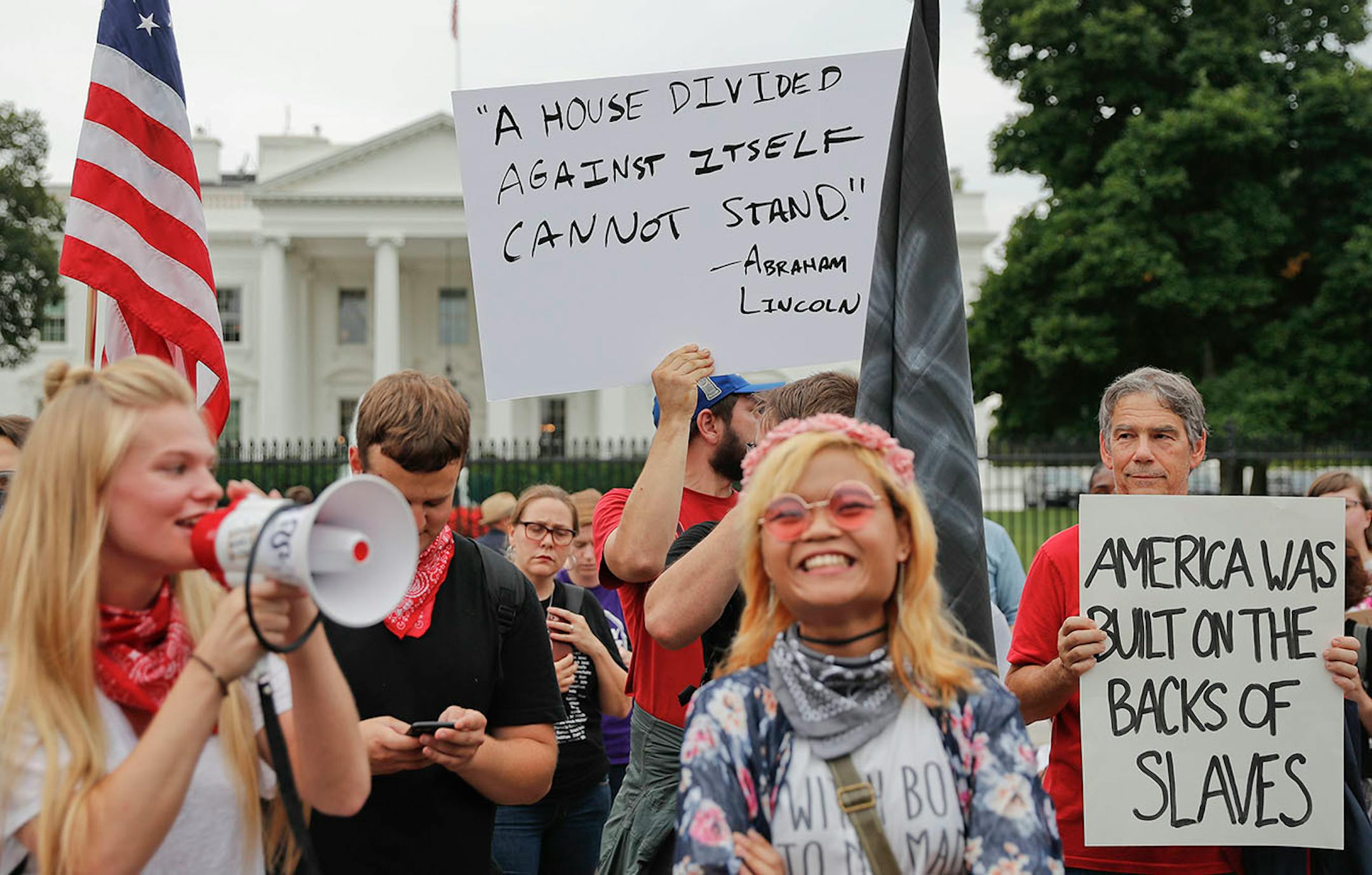 Demonstrators gather on Pennsylvania Avenue in front of the White House in Washington, Monday, Aug. 14, 2017. For the second night in a row, people gathered in front of the White House to protest the white nationalist rally in Charlottesville, Va.