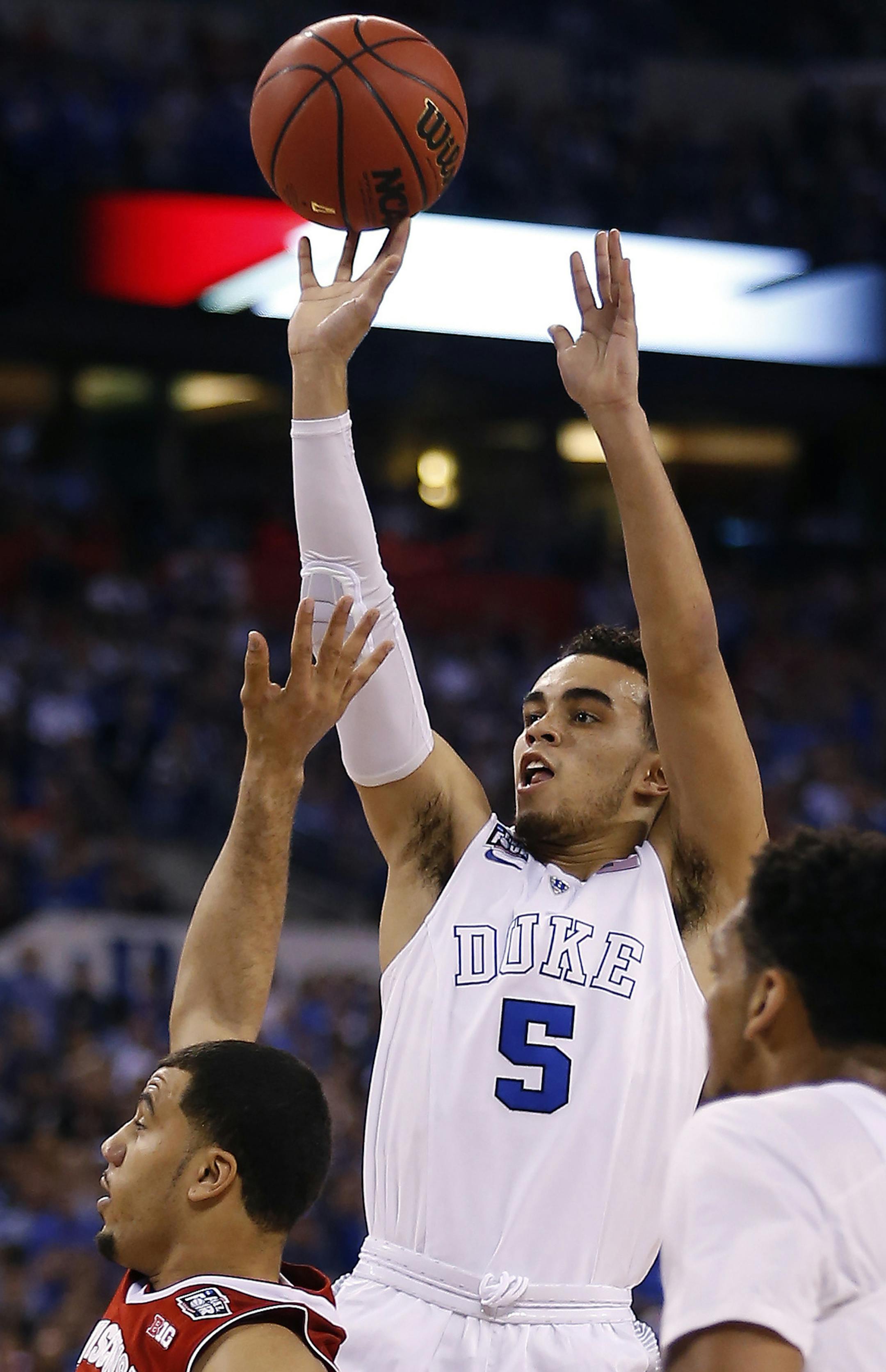 Duke Blue Devils guard Tyus Jones (5) hits a three-pointer during the first half of the NCAA National Championship game on Monday, April 6, 2015, at Lucas Oil Stadium in Indianapolis. (Sam Riche/TNS)