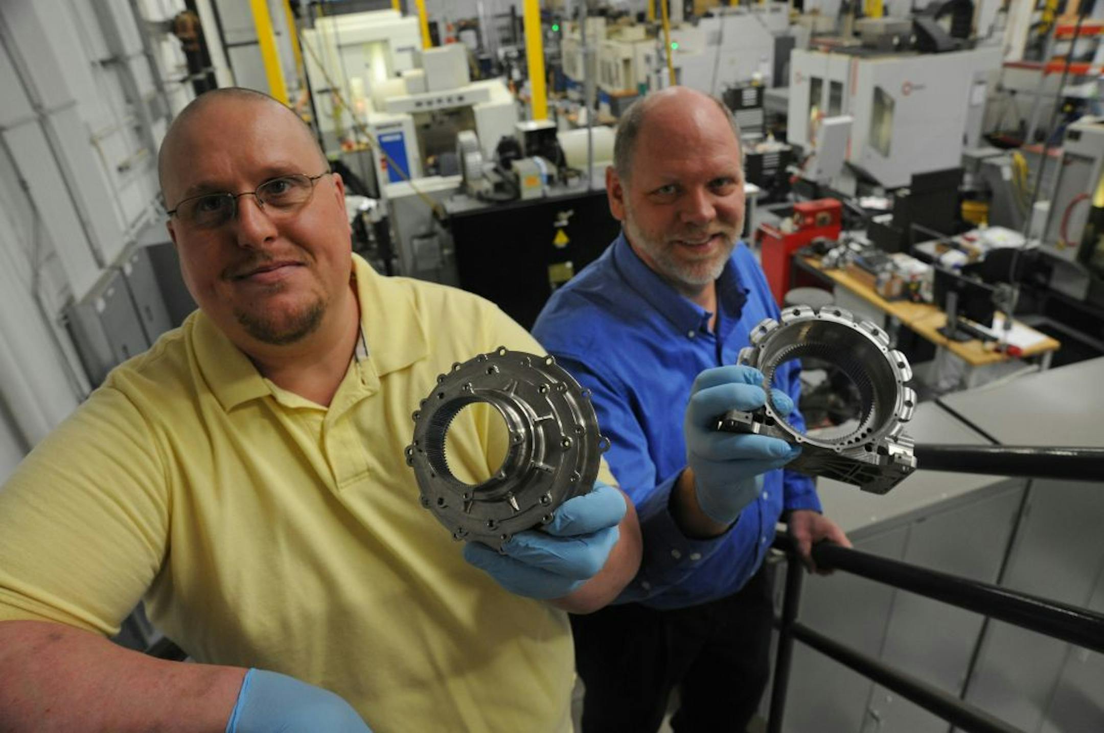 Andrew Tool and Machining of Plymouth made precision-machined gear boxes for the robot arm on the Mars Rover that NASA plans to land on Mars Aug. 5. Jim Breth Project Engineer and Bruce Hanson President, held duplicate parts that were made for the rover. They were standing on a stairway on the main floor of Andrew Tool & Machining on Thursday morning May 3,2012