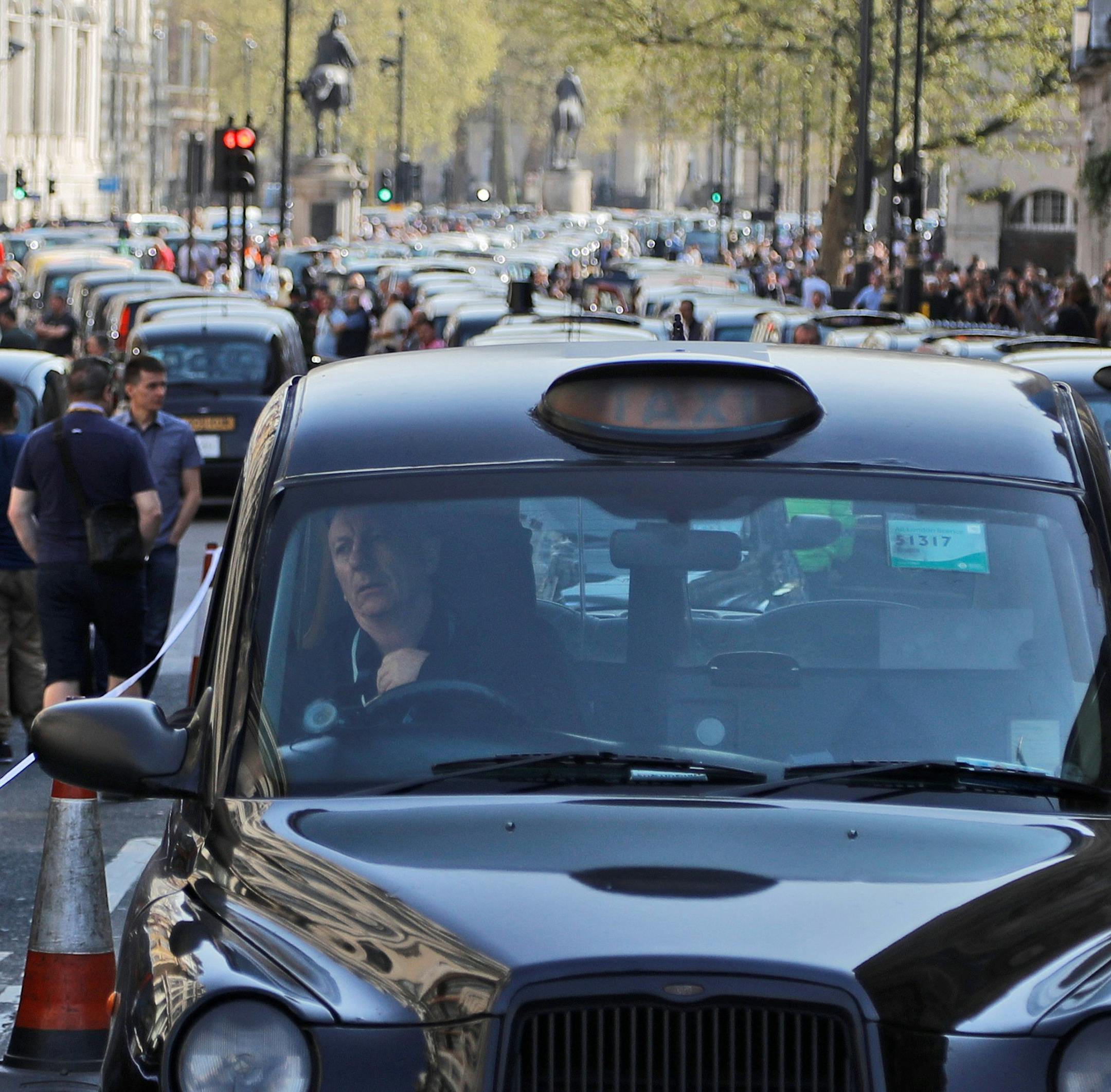 London black cab drivers block a road in Whitehall to protest against government public transport plans, in London, Thursday, April 6, 2017.