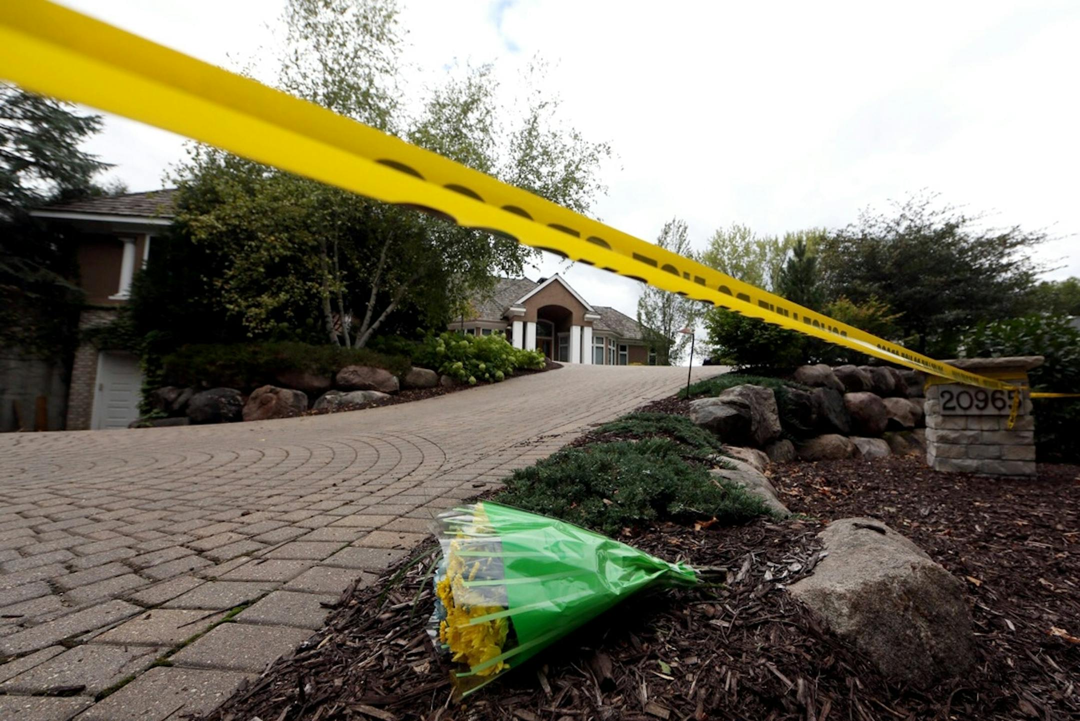 Flowers rest near the driveway of the Short home after the gruesome discovery of the family in their Greenwood, Minn., home.