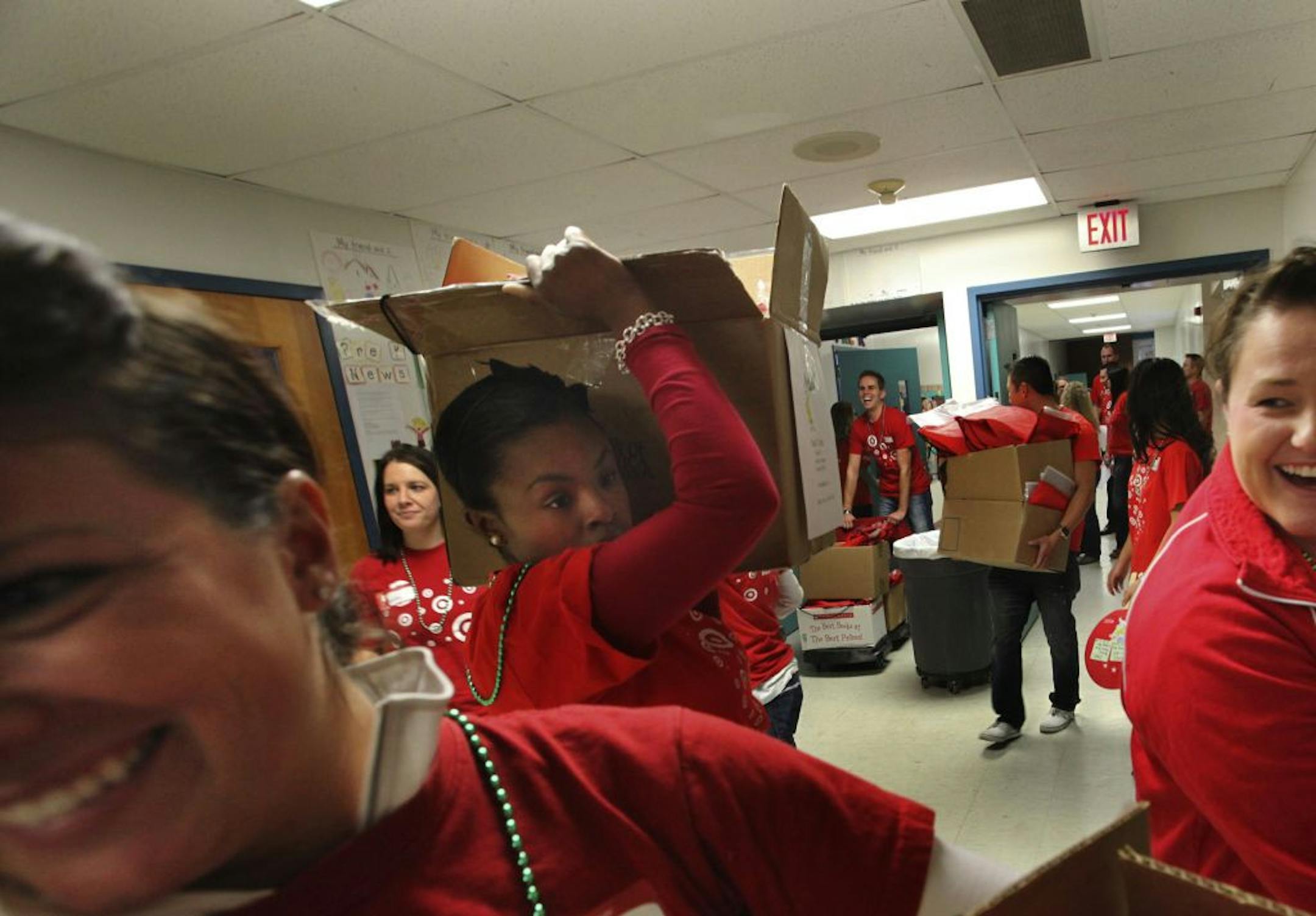 Some of 184 Target volunteers remained upbeat while dealing with a traffic jam at the American Indian Magnet School elevator Thursday, Nov. 1, , 2012, in St. Paul, MN, while on their way to distribute free books to students in their classroom. Among the volunteers was Shawn Johnson, center, with box on her shoulders.
