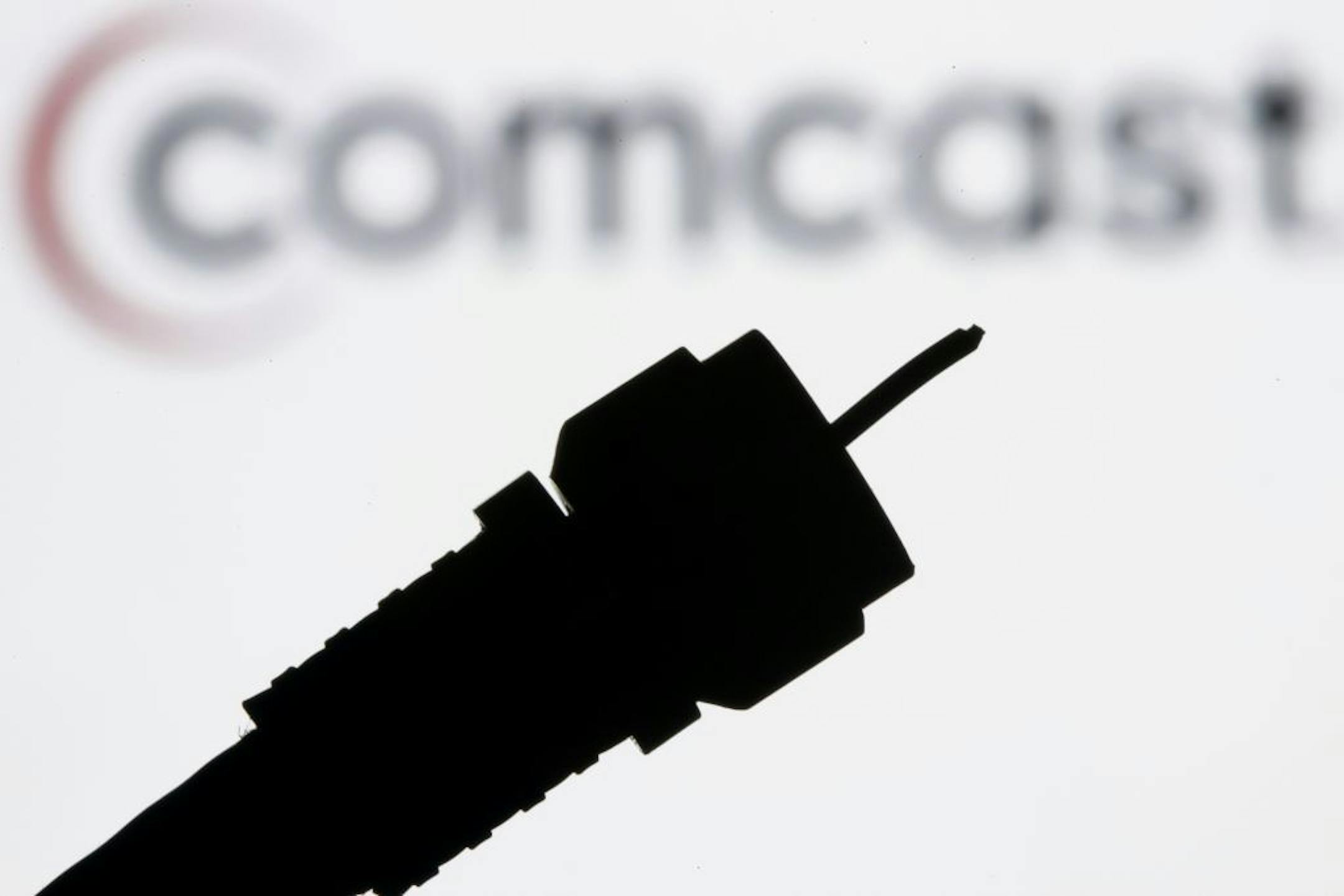 FILE - In this July 30, 2008 file photo illustration, a silhouetted coaxial cable with the Comcast Corp. logo in the background is seen in Philadelphia. At first blush, NBC's $4.4 billion winning bid for the next four Olympic Games _ a billion more than its closest competitor _ was an example of overpaying for an event on which it lost hundreds of millions of dollars.