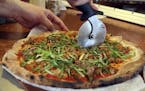 At Pizzeria Lola, pizza chef Bishara Sahoury slices the Lady Za Za pizza -- a kim chi based pizza made with Italian red sauce, house-made kimchi, Kore