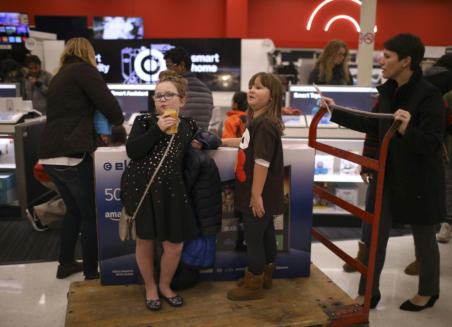 Cousins Dianna, left, and Eleanor Lenz rode on the cart holding a 50-inch flat-screen television pushed by Dianna's mom, Sarah Lenz, on a shopping trip to Target's Ridgedale location on Thursday night.