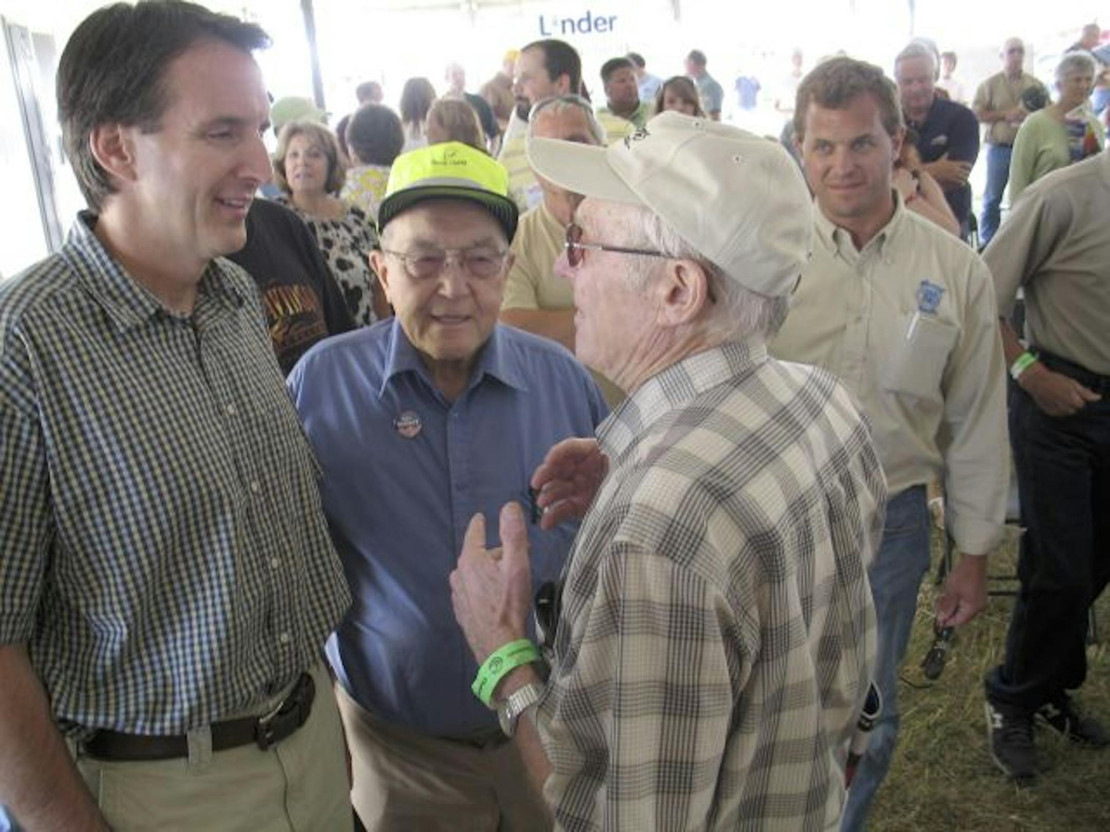 Gov. Tim Pawlenty spoke with Larry Hansen of Tyler, center, and Howard Swenson of Nicollet on Thursday at Farmfest at Gilfilan Estate in rural Redwood Falls, Minn.