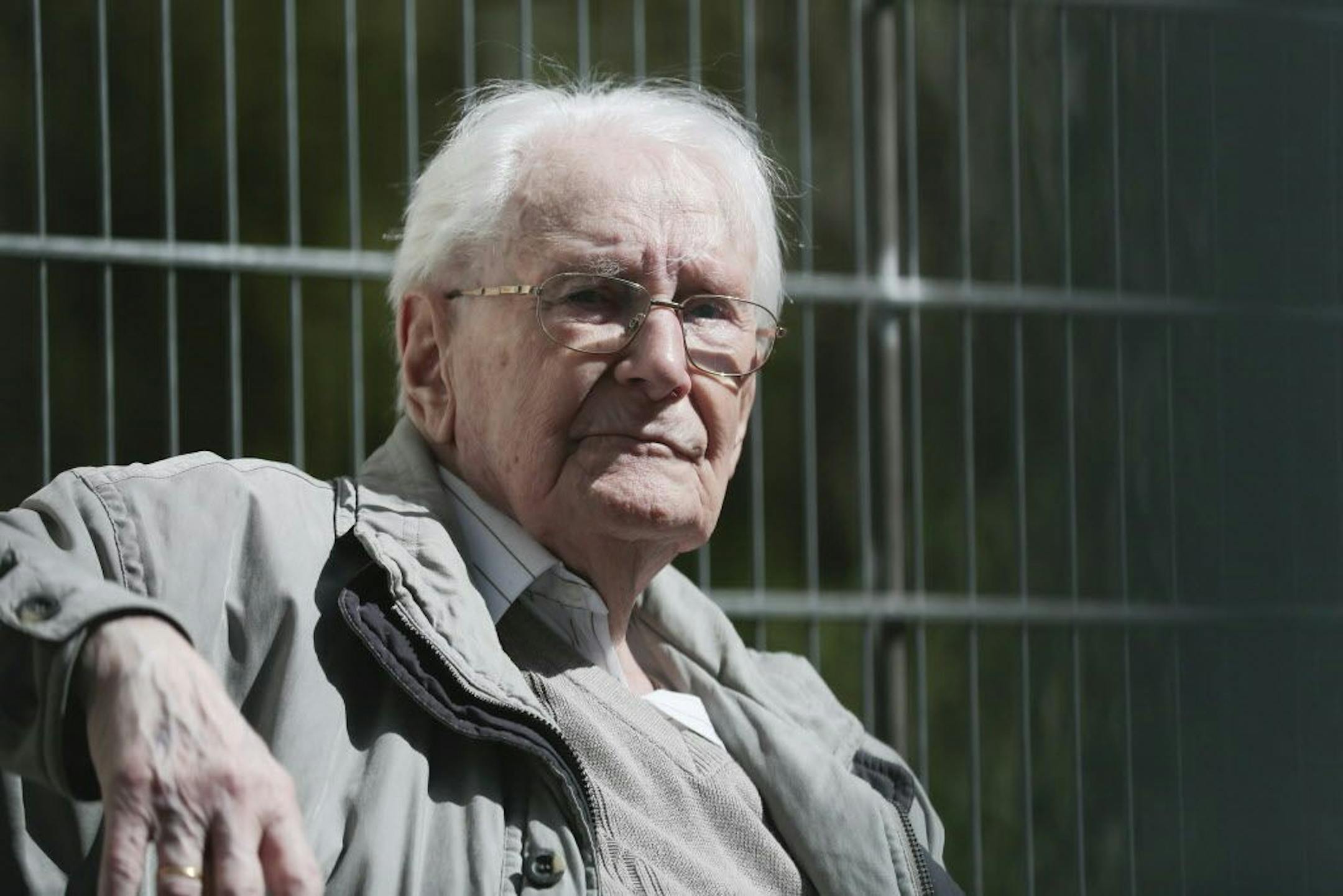 Former SS guard Oskar Groening sits in ths sun during the noon break of the trial against him in Lueneburg, northern Germany, Tuesday, April 21, 2015.