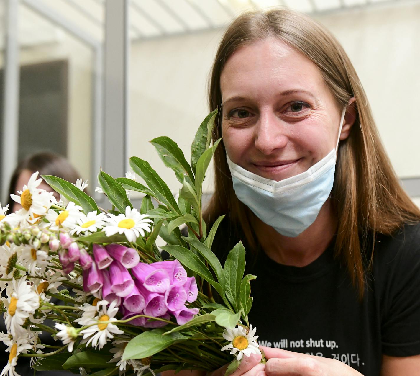 Russian journalist Svetlana Prokopyeva holds a bunch of flowers after a court session in Pskov, Russia, Monday, July 6, 2020. A court in the city of Pskov convicted Prokopyeva on charges of condoning terrorism on Monday and ordered her to pay a fine in a case that has been widely criticized as an attack on freedom of speech. (AP Photo)