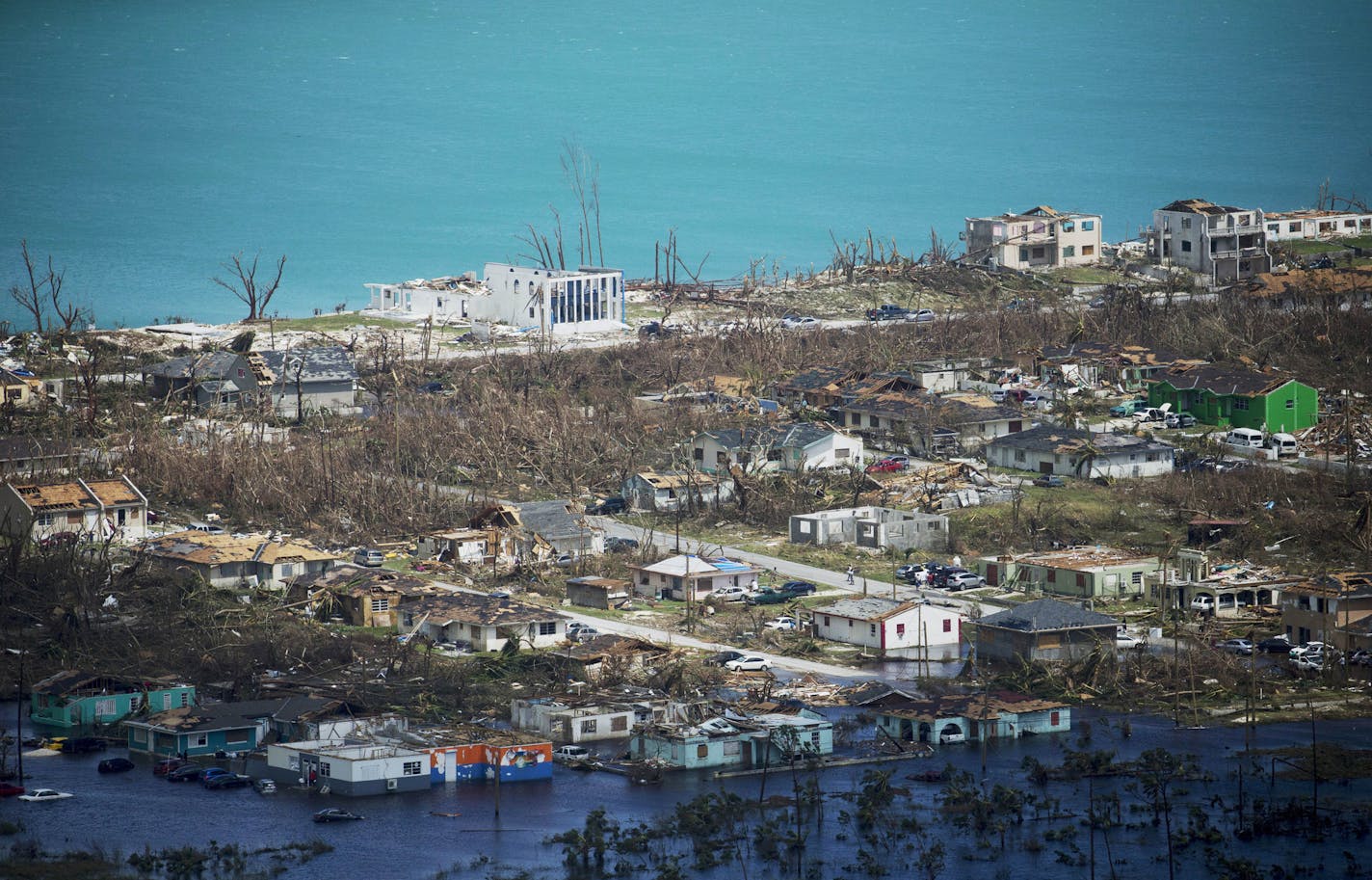 In this Wednesday, Sept. 4, 2019 photo, extensive damage from Hurricane Dorian can be seen in this aerial photo over the Island of Abaco, Bahamas. The Category 5 storm battered the island chain. Abaco and Grand Bahama islands are known for their marinas, golf courses and all-inclusive resorts and are home to many fishermen, laborers and hotel workers. The official death toll from the government stood at 20 and was certain to climb. (Andrew West/The News-Press via AP)