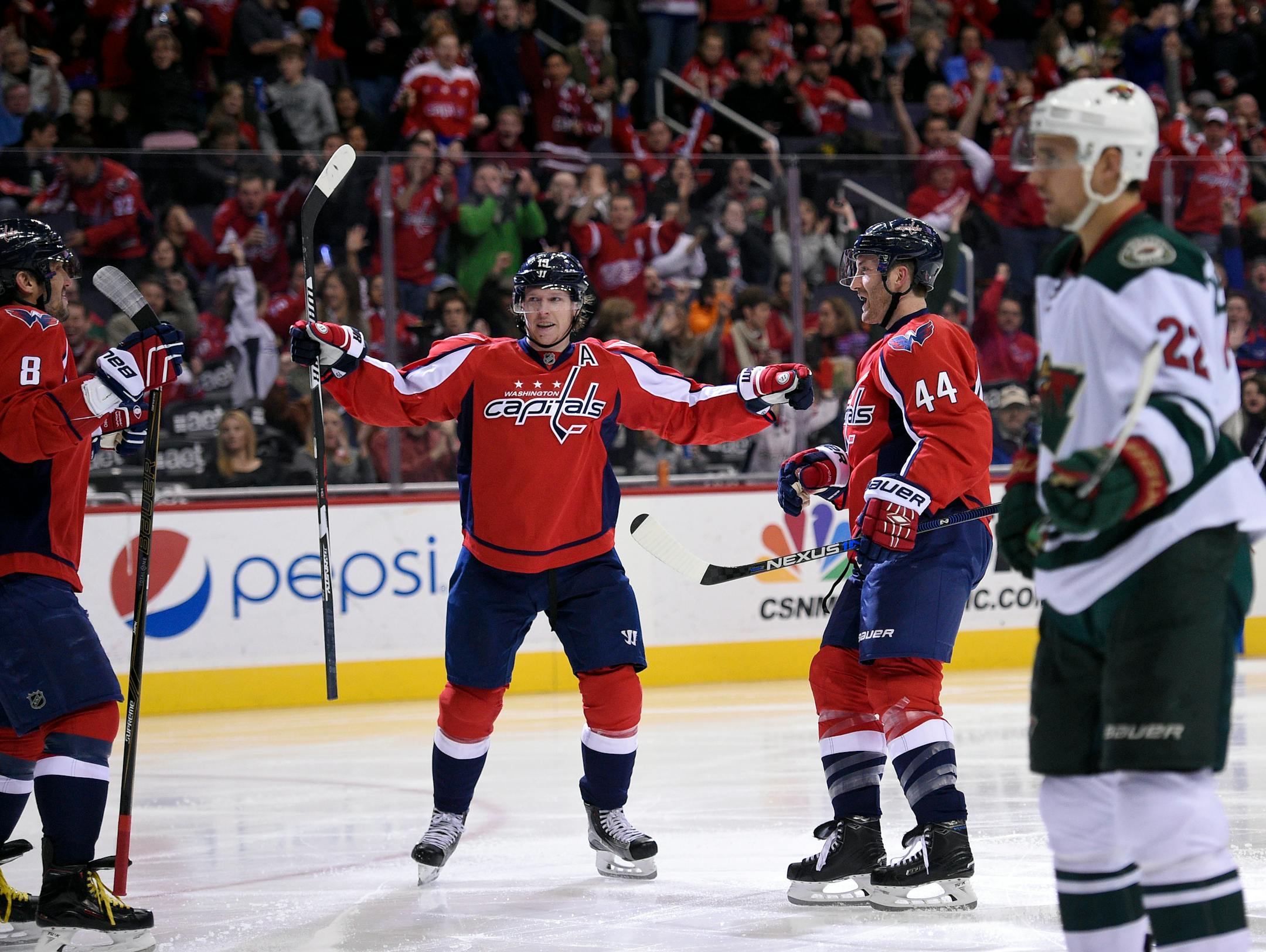 Washington Capitals defenseman Brooks Orpik (44) celebrates his goal with center Nicklas Backstrom (19), of Sweden, and left wing Alex Ovechkin (8), of Russia, during the second period of an NHL hockey game, as Minnesota Wild right wing Nino Niederreiter (22) skates by, Friday, Feb. 26, 2016, in Washington. (AP Photo/Nick Wass)