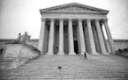 An officer patrols the steps of the Supreme Court building, on Capitol Hill in Washington, March 3, 2015.
