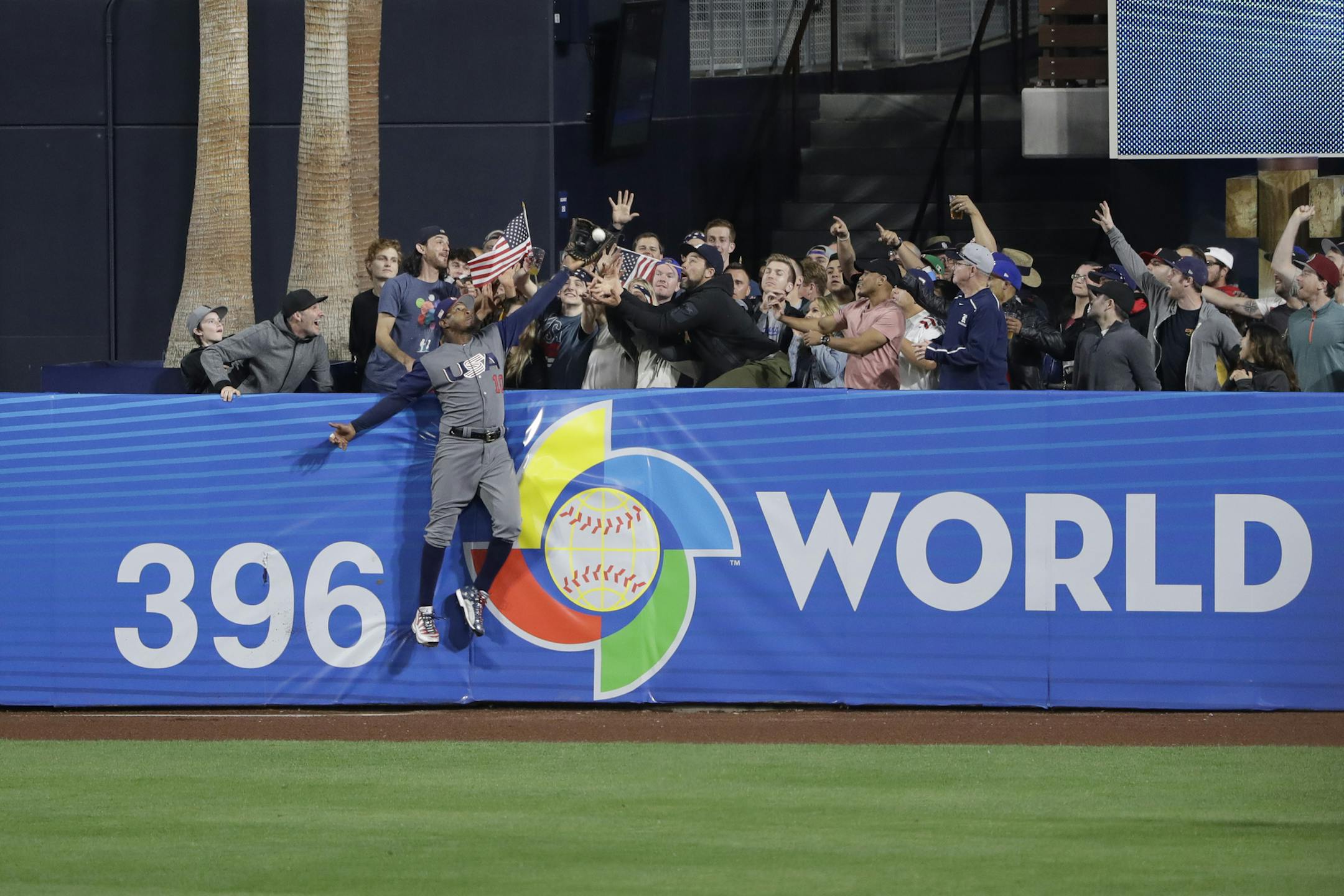 United States outfielder Adam Jones grabs a catch above the wall for the out on the Dominican Republic's Manny Machado during the seventh inning of a second-round World Baseball Classic baseball game Saturday, March 18, 2017, in San Diego. (AP Photo/Gregory Bull)