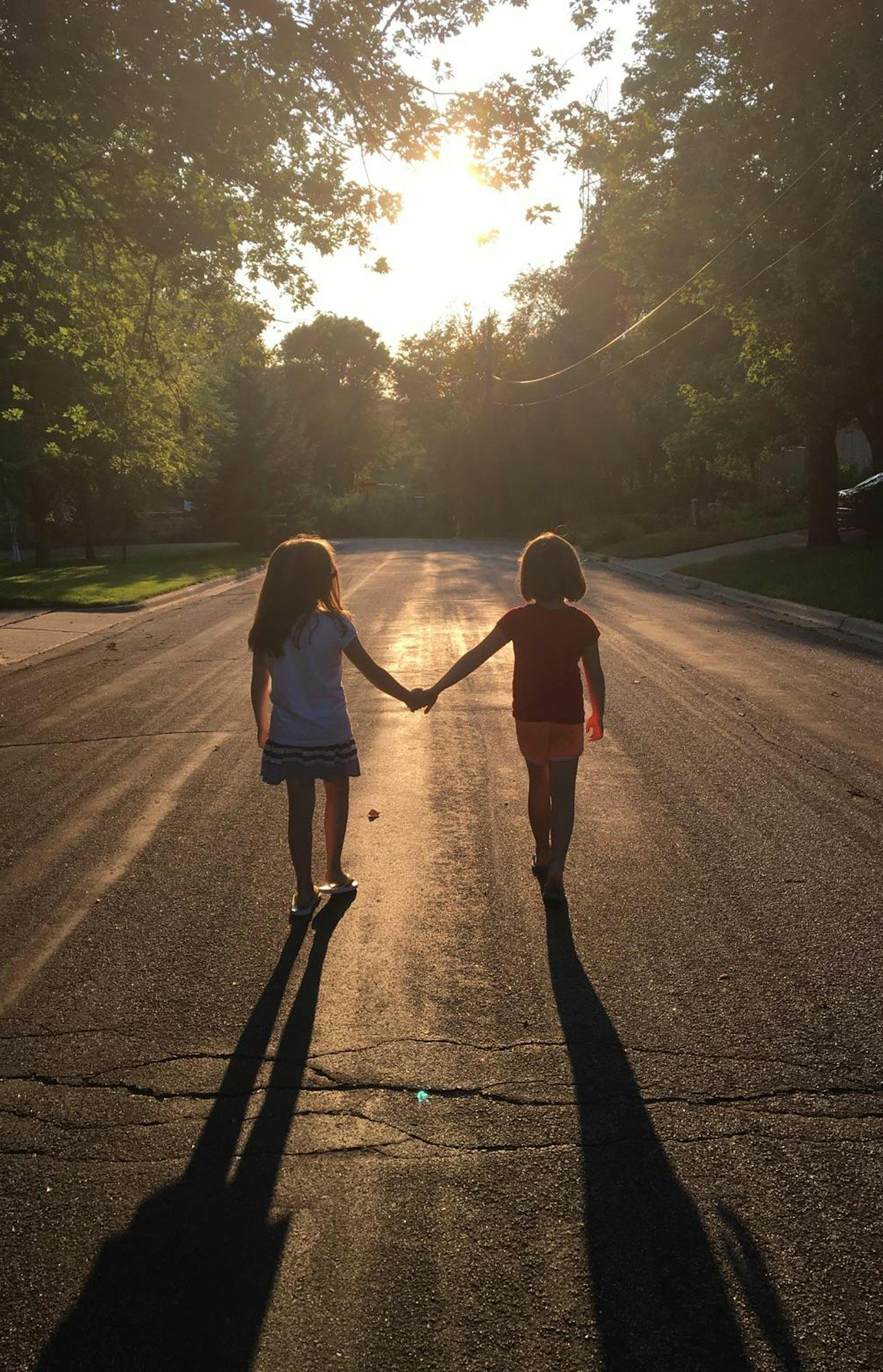This picture of my grand daughters, Alison and Madison Bliss, were 8 when it was taken late Summer of 2016 as they walked down the street in front of their home in Edina. Behind the camera is their neighbor and bff Siri Larson. Siri, who was 11 at the time, had just been given her first phone and was practicing with the camera. This is the first photo she took! I smile everytime I look at it. It captures perfectly the love these girls have for each other. They are as different as night and day b