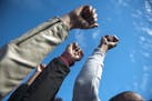 Protesters raise their fists to celebrate Tim Wolfe's resignation during the Concerned Students 1950 protest on Monday, Nov. 9 2015, in Columbia, Mo. 