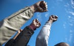 Protesters raise their fists to celebrate Tim Wolfe's resignation during the Concerned Students 1950 protest on Monday, Nov. 9 2015, in Columbia, Mo. 