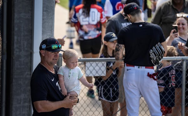 St. Paul Saints manger Toby Gardenhire, held his 8 month old son Bodie , as Twins shortstop Carlos Correa (4) gave fans autographs to fans Tuesday ,Fe