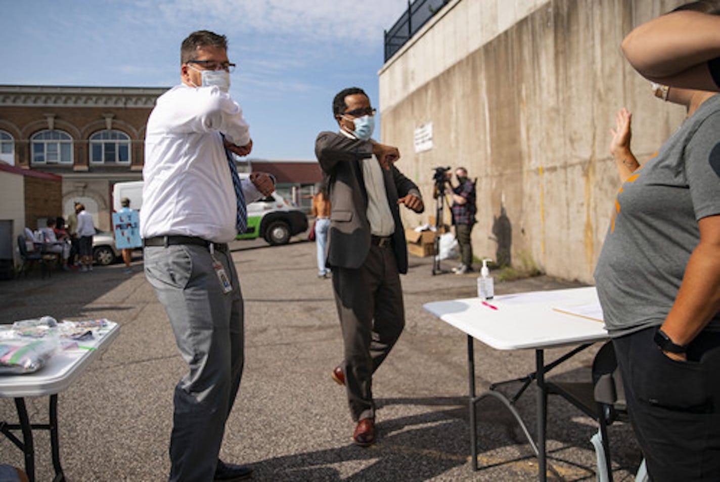 (Left) New Duluth public schools superintendent John Magas and new assistant superintendent Anthony Bonds gave elbow greetings to Duluth teachers at the backpack giveaway on Tuesday morning outside CHUM Food Shelf. ] ALEX KORMANN • alex.kormann@startribune.com Local teachers from Duluth area schools volunteered to hand out backpacks, school supplies and face masks to students on Tuesday August 25, 2020. The giveaway was organized in part by CHUM Food Shelf, where it also took place.