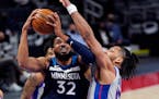 Timberwolves center Karl-Anthony Towns attempts a layup as Detroit center Jahlil Okafor defends during the first half