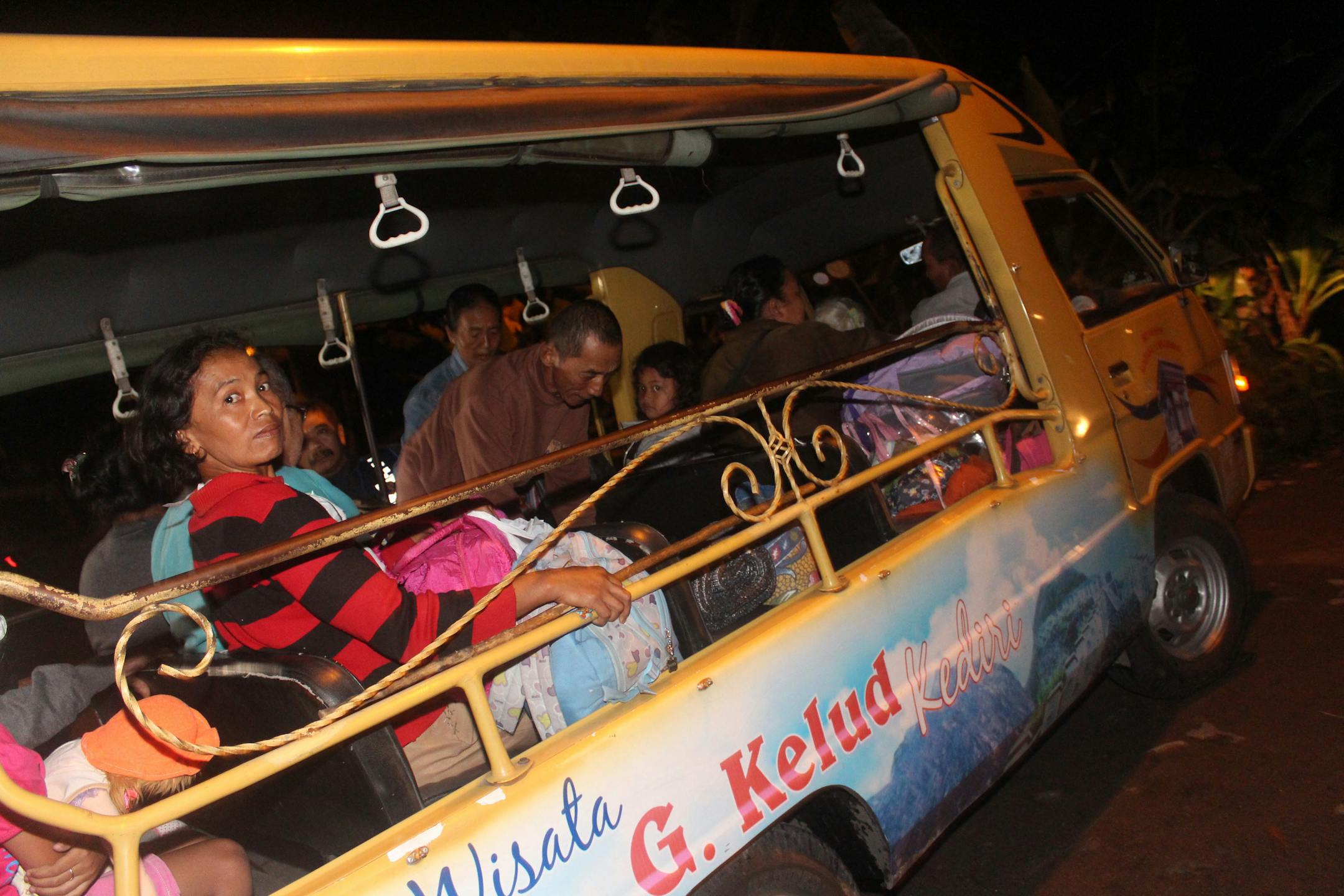 Villagers sit inside a bus as they are evacuated from their homes on the slope of Mount Kelud in Kediri, East Java, Indonesia, Thursday, Feb. 13, 2014.