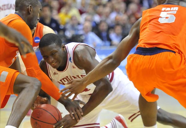 Indiana guard Victor Oladipo (4), center, goes to the floor for the ball between Syracuse center Baye Keita (12) and Syracuse forward C.J. Fair (5) in
