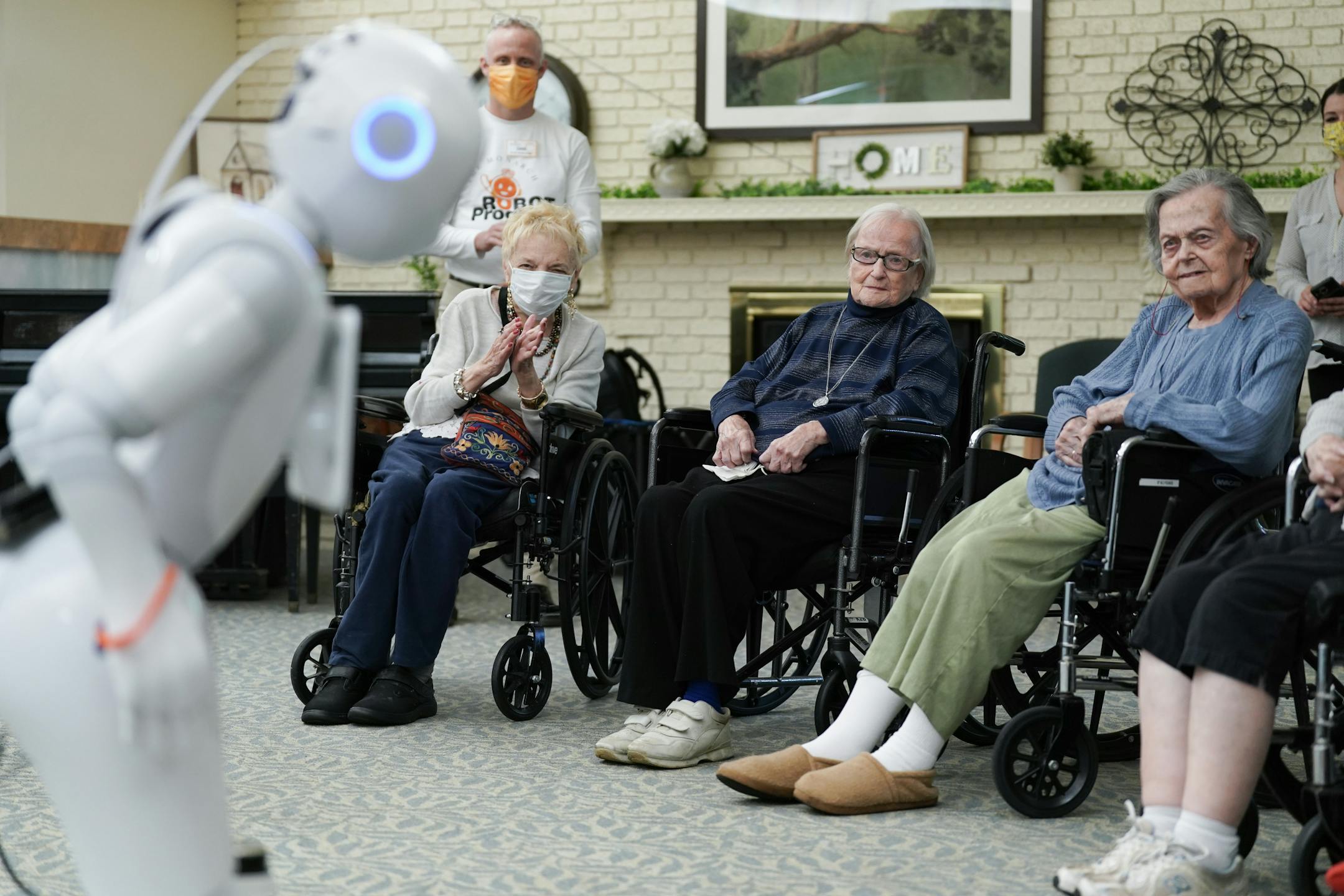 Nursing home residents Carol Jones, Carol Fisher, and Irene Struck listened as Pepper, a new robotic assistant, performed an adult-themed comedy routine about her electronic relationships.