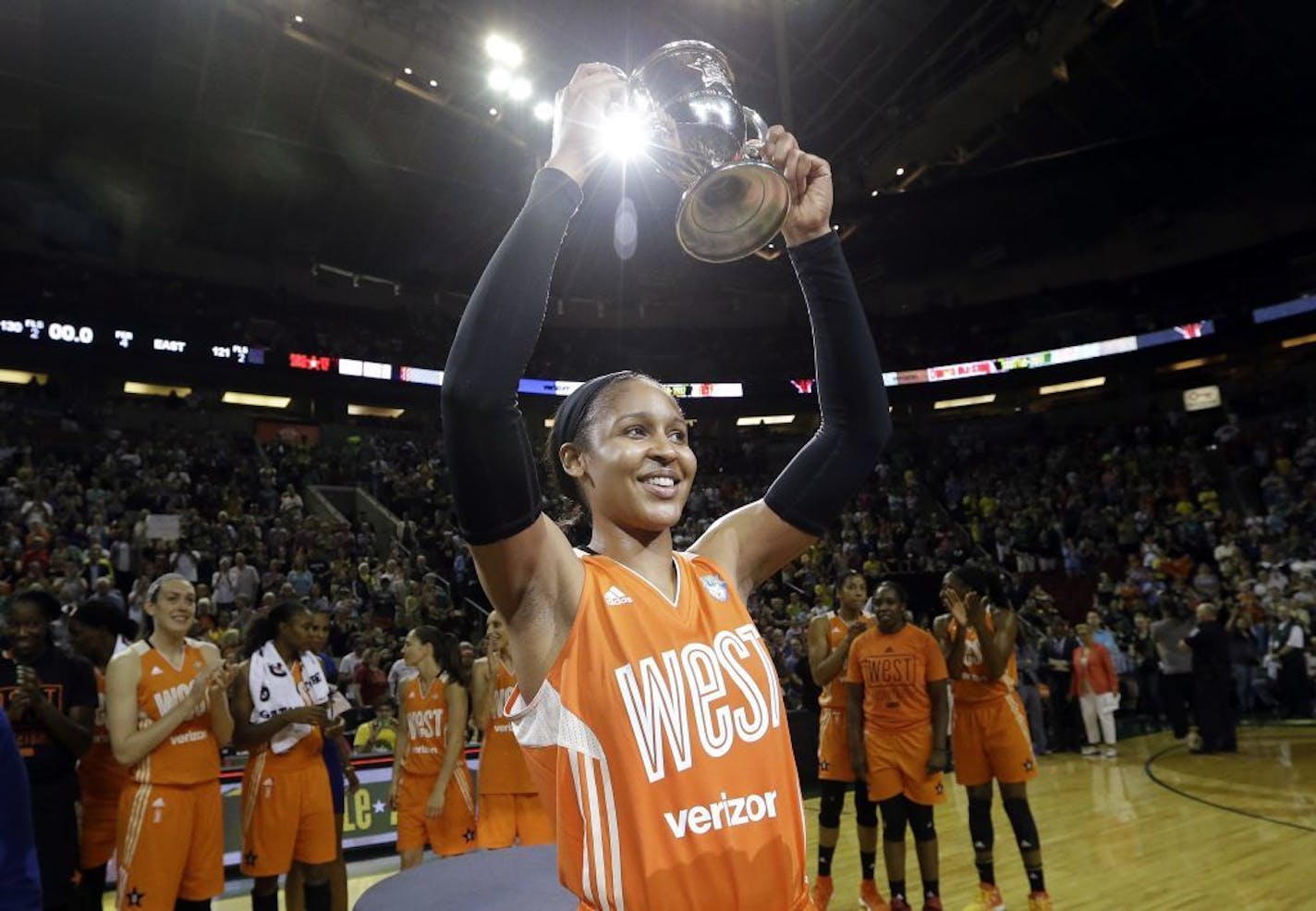 Minnesota Lynx's Maya Moore, of the Western Conference, holds up a trophy after being named most valuable player as teammates cheer behind after the WNBA All-Star basketball game Saturday, July 22, 2017, in Seattle.