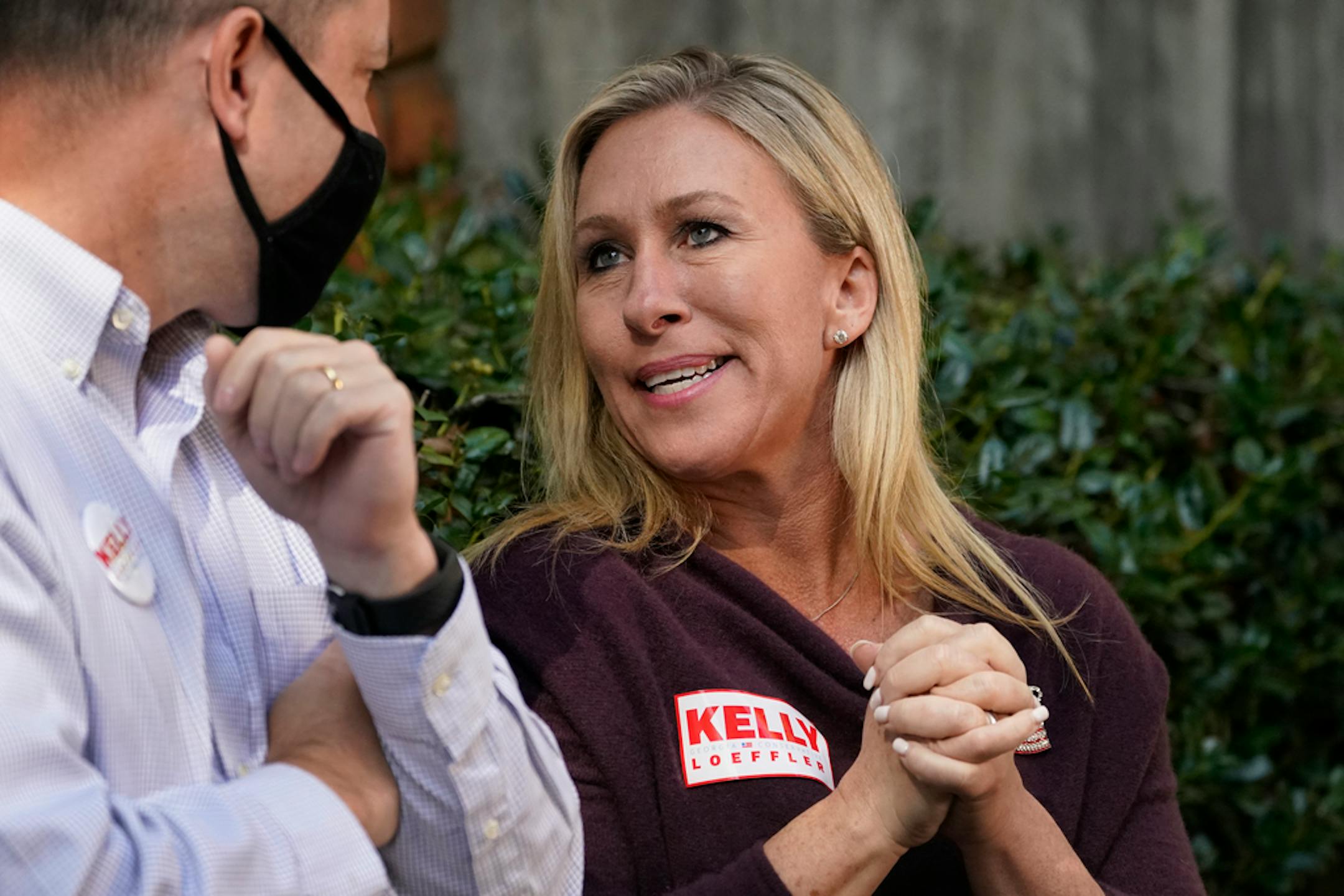 Republican candidate for Georgia's 14th congressional seat Marjorie Taylor Greene speaks to Georgia attorney general Chris Carr during a campaign rally for Republican Sen. Kelly Loeffler Saturday, Oct. 31, 2020, in Roswell, Ga. (AP Photo/John Bazemore)