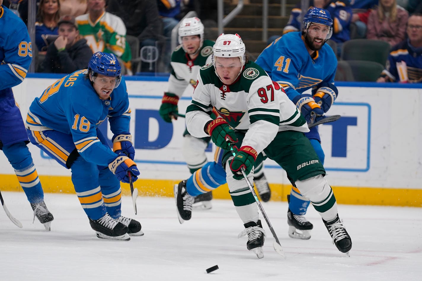 Minnesota Wild's Kirill Kaprizov (97) controls the puck as St. Louis Blues' Robert Thomas (18) and Robert Bortuzzo (41) defend during the first period of an NHL hockey game Saturday, April 16, 2022, in St. Louis. (AP Photo/Jeff Roberson)