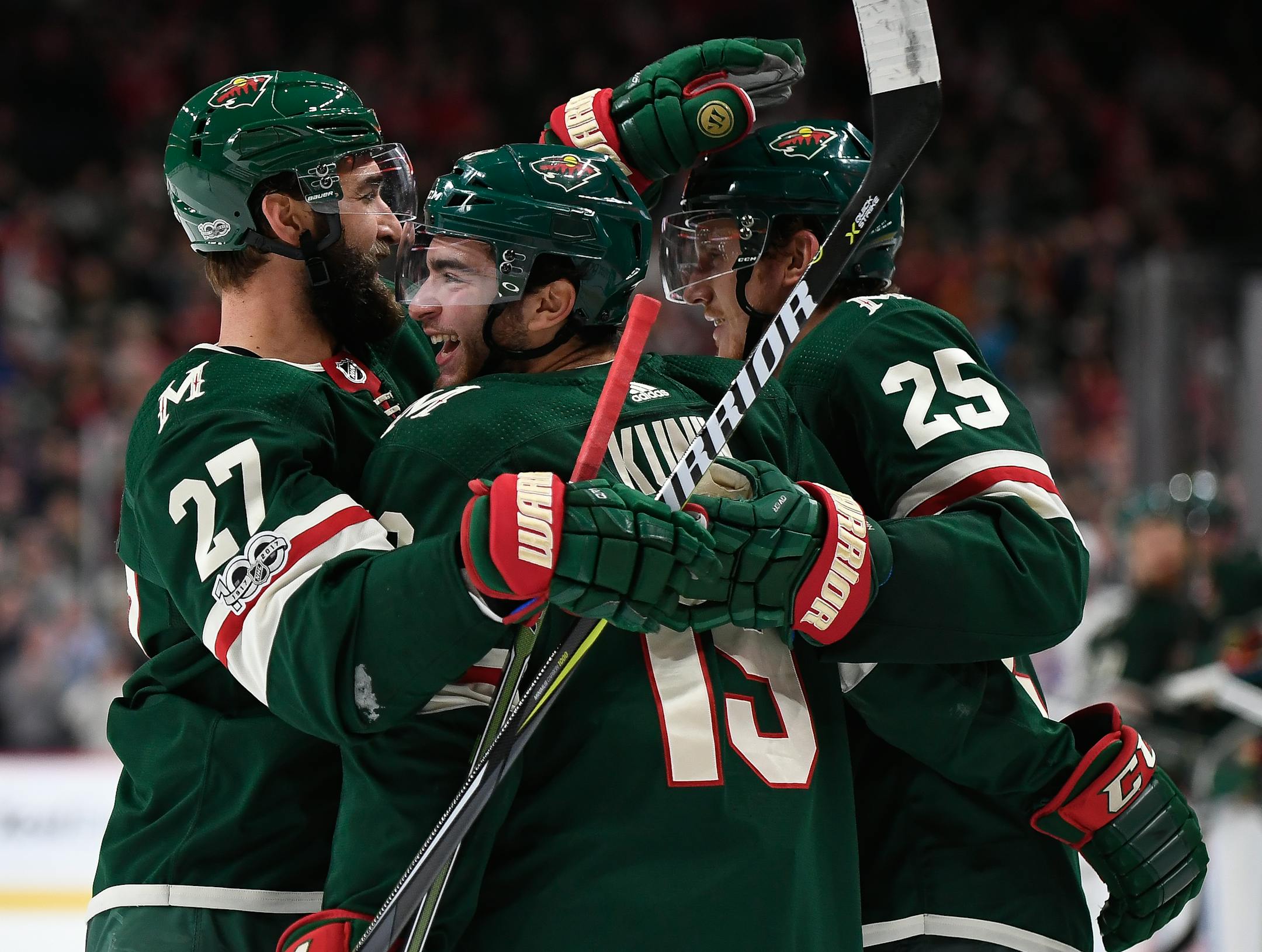 The Minnesota Wild's Kyle Quincey (27) and Jonas Brodin (25) celebrate with Luke Kunin (19) after Kunin scored the first NHL goal of his career in the second period against the New York Islanders