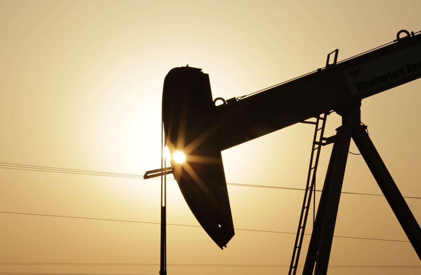 FILE- In this Wednesday, Sept. 30, 2015 file photo, an oil pump works at sunset in the desert oil fields of Sakhir, Bahrain. OPEC member states and other major oil producers are planning to meet next month to discuss a freeze in oil output levels, Qatar's top energy official said Wednesday. (AP Photo/Hasan Jamali, file)