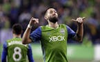 Seattle Sounders' Clint Dempsey motions to fans after scoring the second of his two goals against the Vancouver Whitecaps in the second half of the se