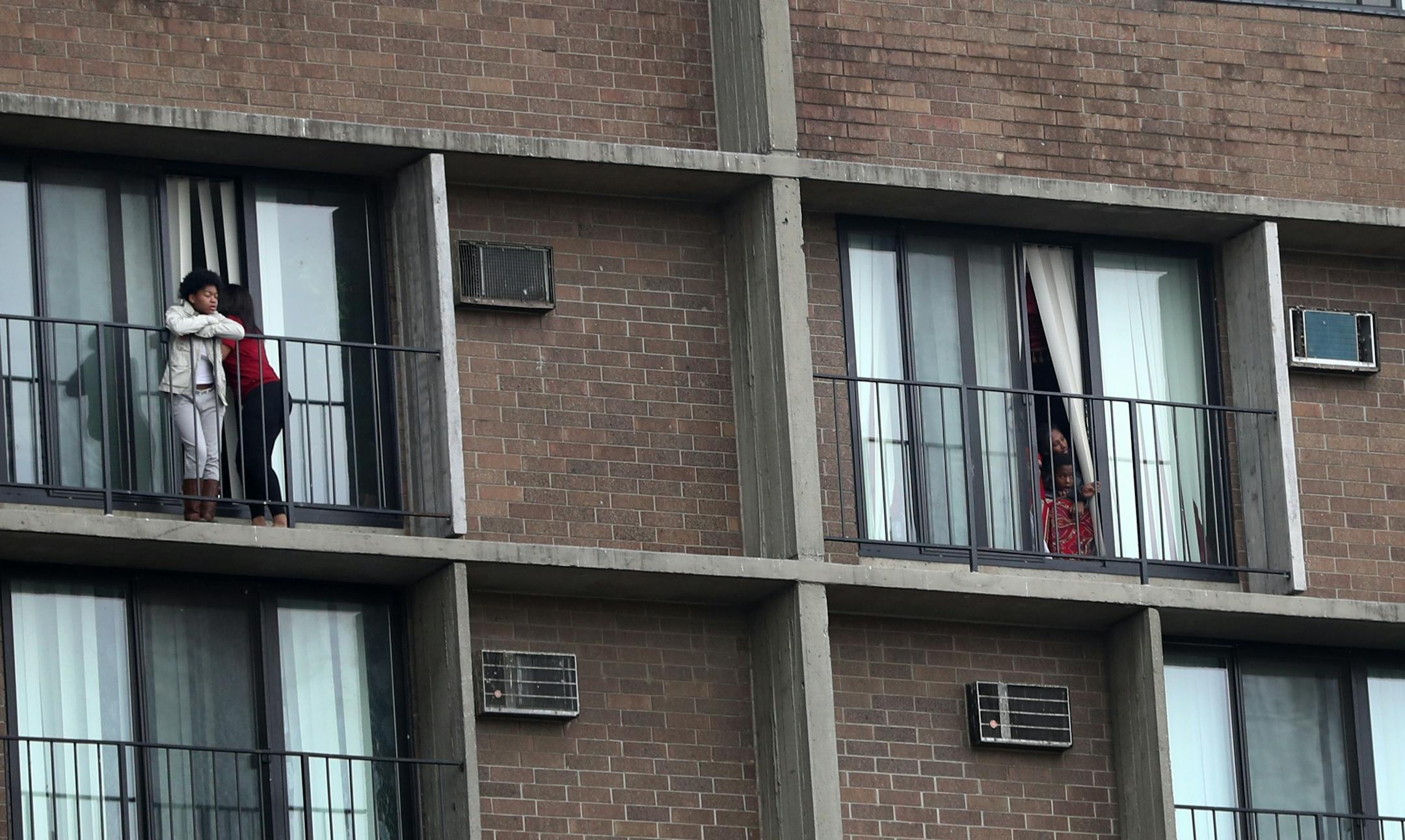 Young people come out of a high-rise apartment in Cedar-Riverside during The Caravan of Love: A Walk of Love for Immigrants and Refugees.