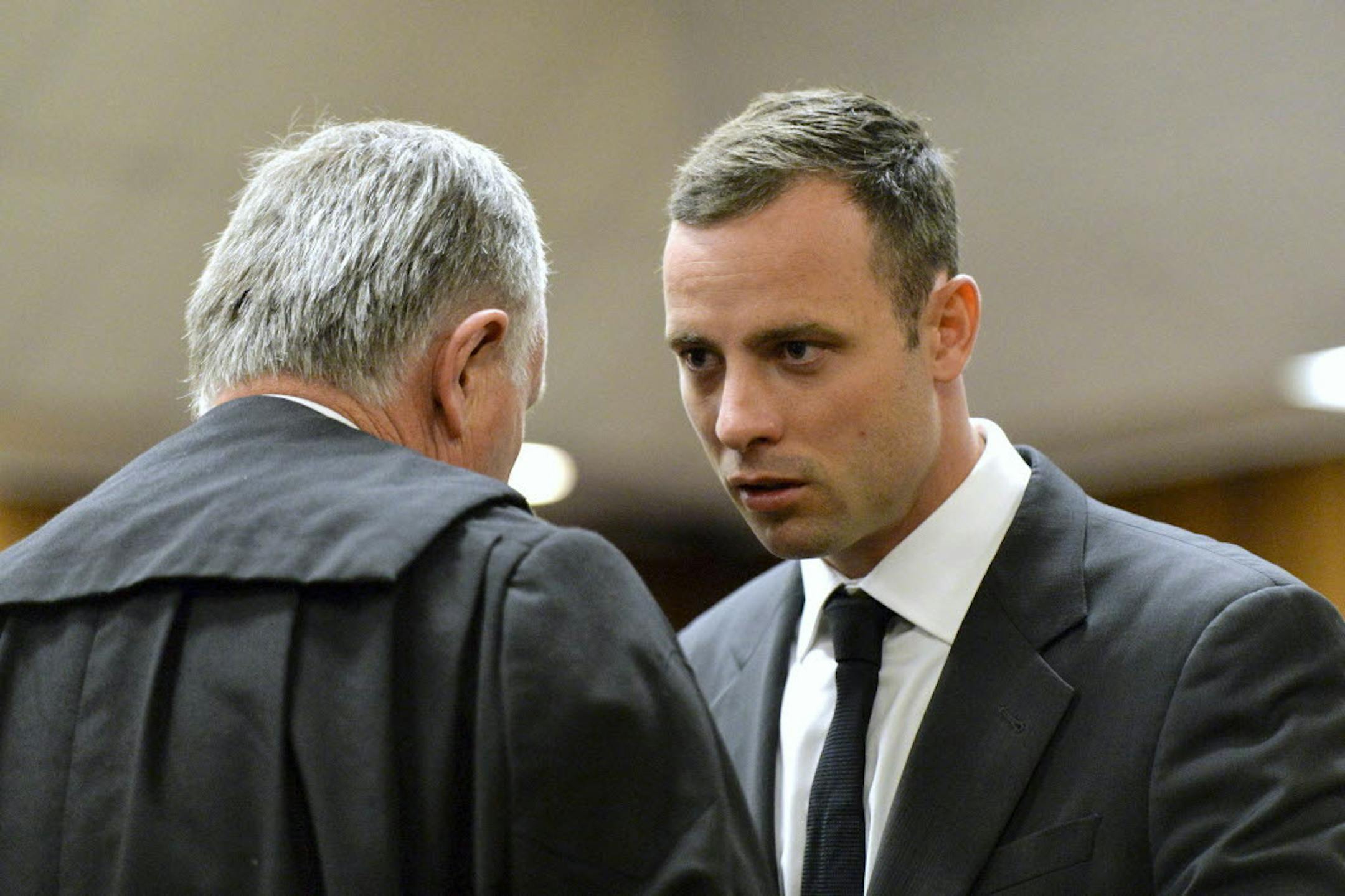 March 3, 2014: Oscar Pistorius, right, speaks with his lawyer Barry Roux.