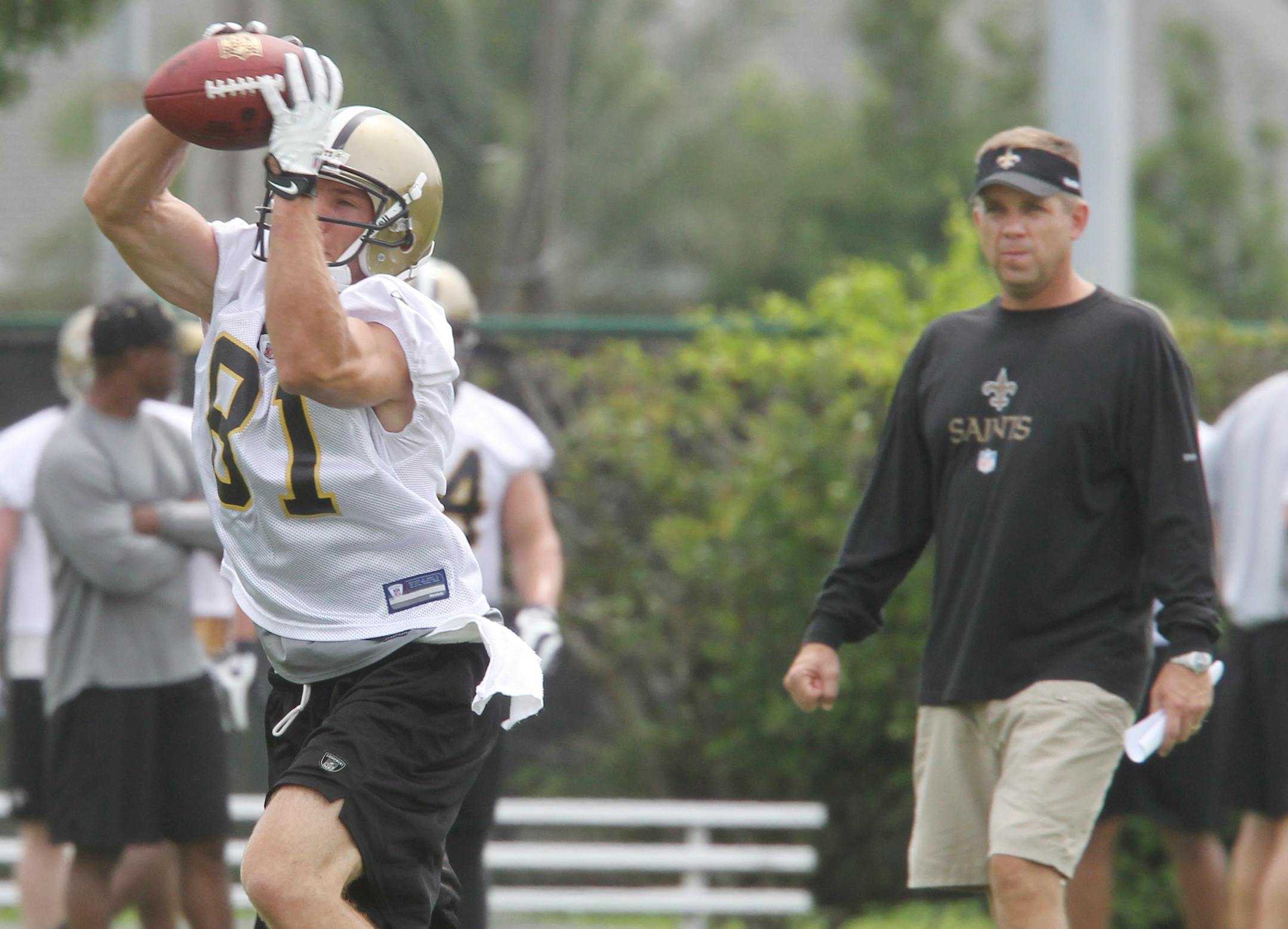 New Orleans Saints coach Sean Payton watches as wide receiver Matt Simon (81) catches a pass during the stretching exercises at the start of practice at the club's NFL football training facility in Metairie, La., Friday, June 4, 2010. (AP Photo/Bill Haber)