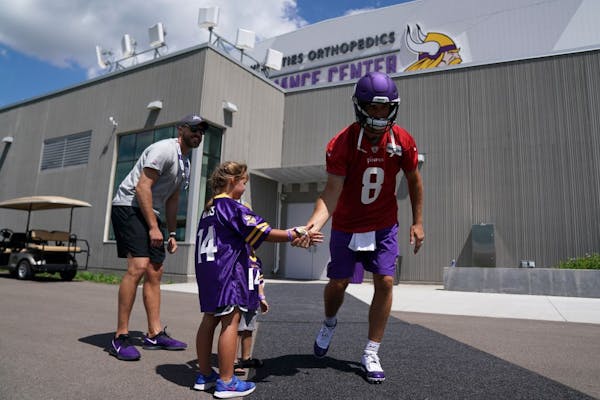 Minnesota Vikings quarterback Kirk Cousins (8) got some encouragement from a pair of young fans as he took the field for the afternoon session during 