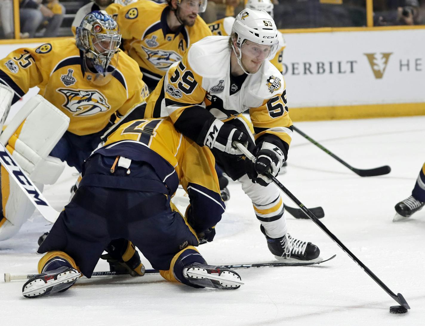 Pittsburgh Penguins forward Jake Guentzel (59) moves the puck past Nashville Predators defenseman Ryan Ellis during Saturday night's Game 3 of the Stanley Cup Final. Guentzel scored his 13th playoff goal Saturday, one short of the rookie record set by Dino Ciccarelli in 1981.