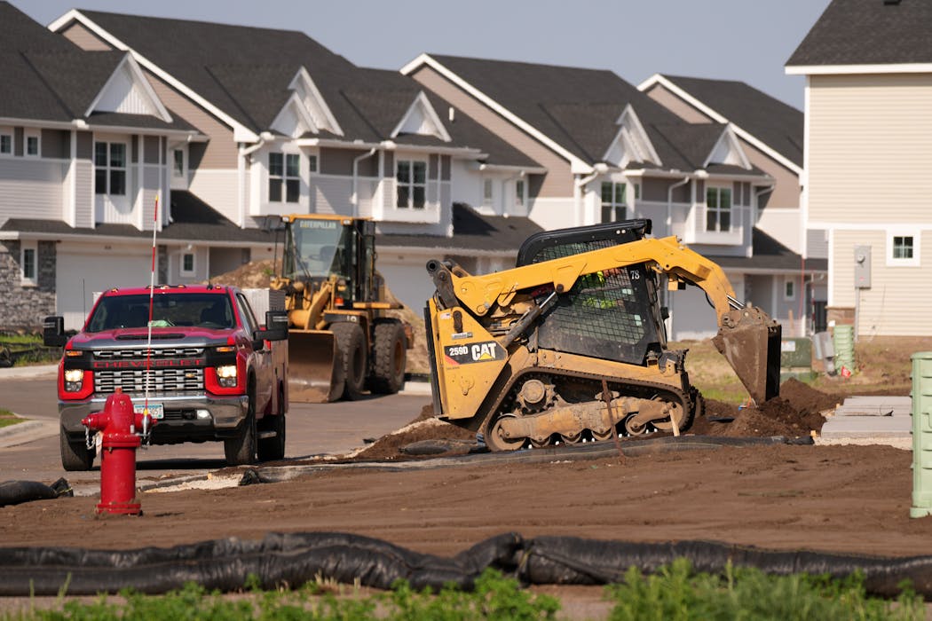 Construction crews work at the Lennar at Lynwood housing development in Ramsey on Tuesday. Finished units are in the background. 