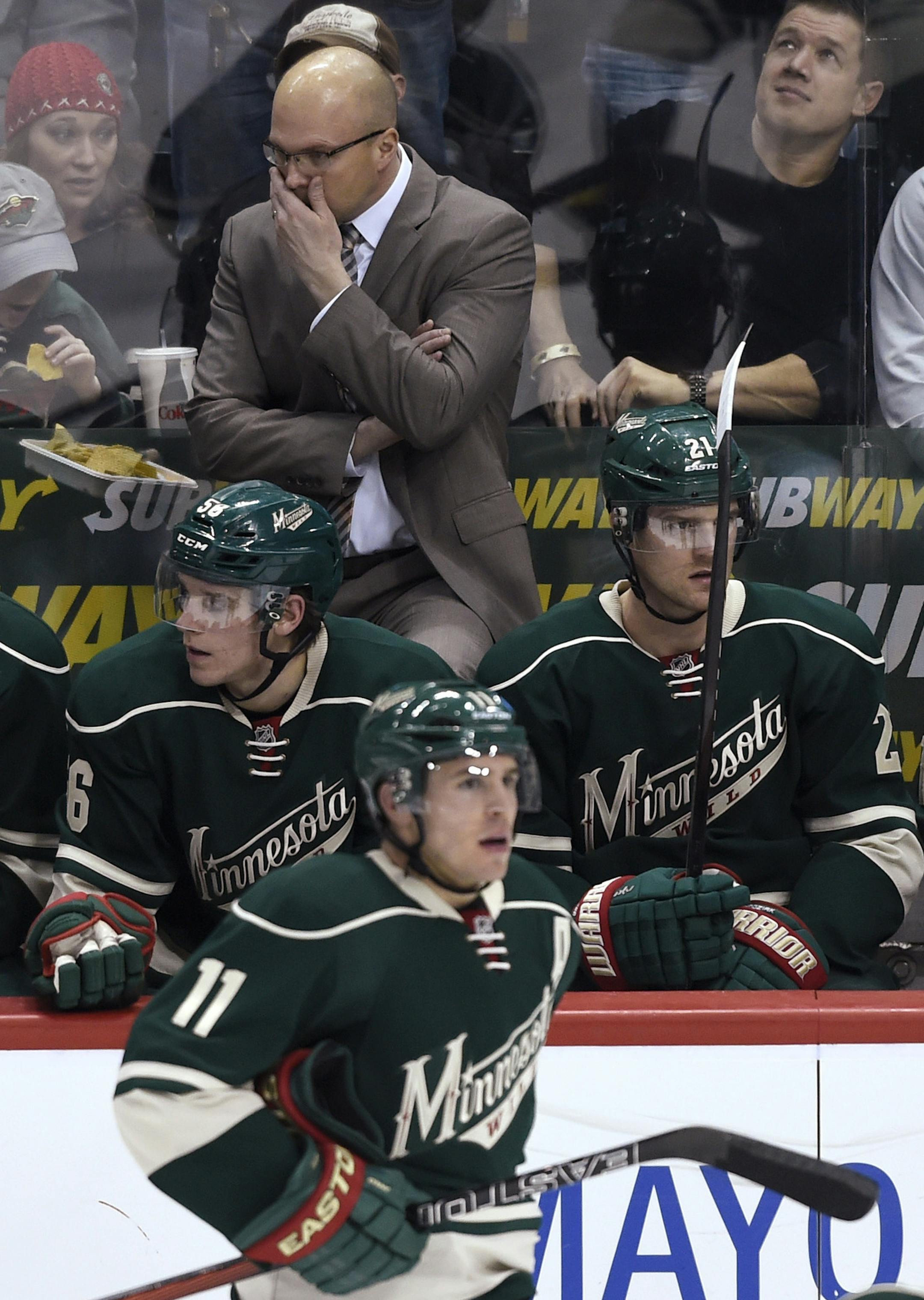 Minnesota Wild coach Mike Yeo stands behind players on the bench during the third period of the Wild's NHL hockey game against the Arizona Coyotes on Saturday, Jan. 17, 2015, in St. Paul, Minn. The Wild won 3-1. (AP Photo/Hannah Foslien)