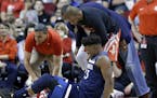 Minnesota Timberwolves guard Jimmy Butler (23) reacts to a knee injury on the court as Houston Rockets guard Chris Paul (3) and team trainers hover ov