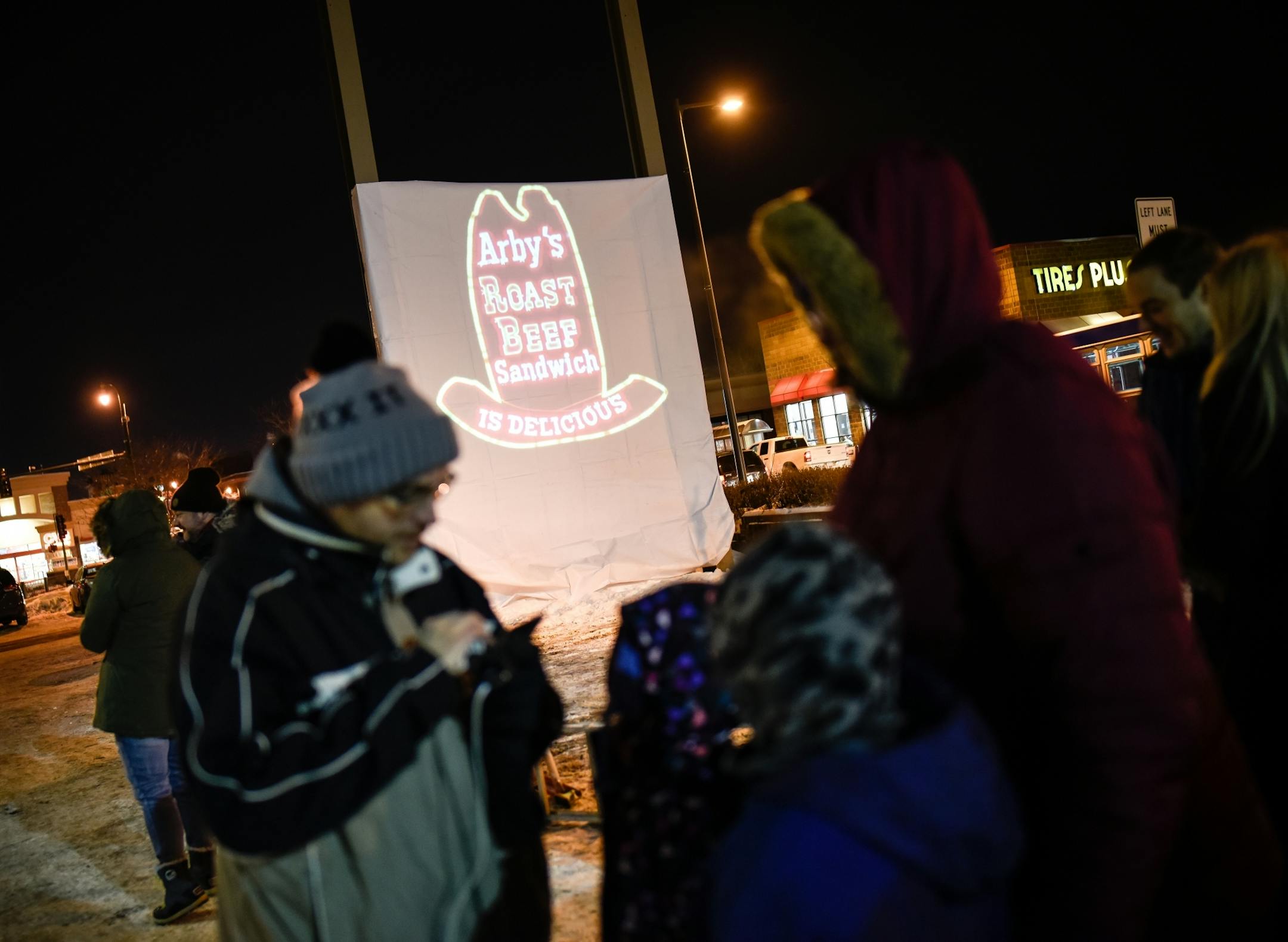 Vigil goers began to gather near the location of the former Uptown Arby's sign Friday night.