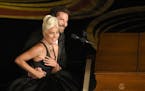Lady Gaga, left, and Bradley Cooper react to the audience after a performance of "Shallow" from "A Star is Born" at the Oscars on Sunday, Feb. 24, 201