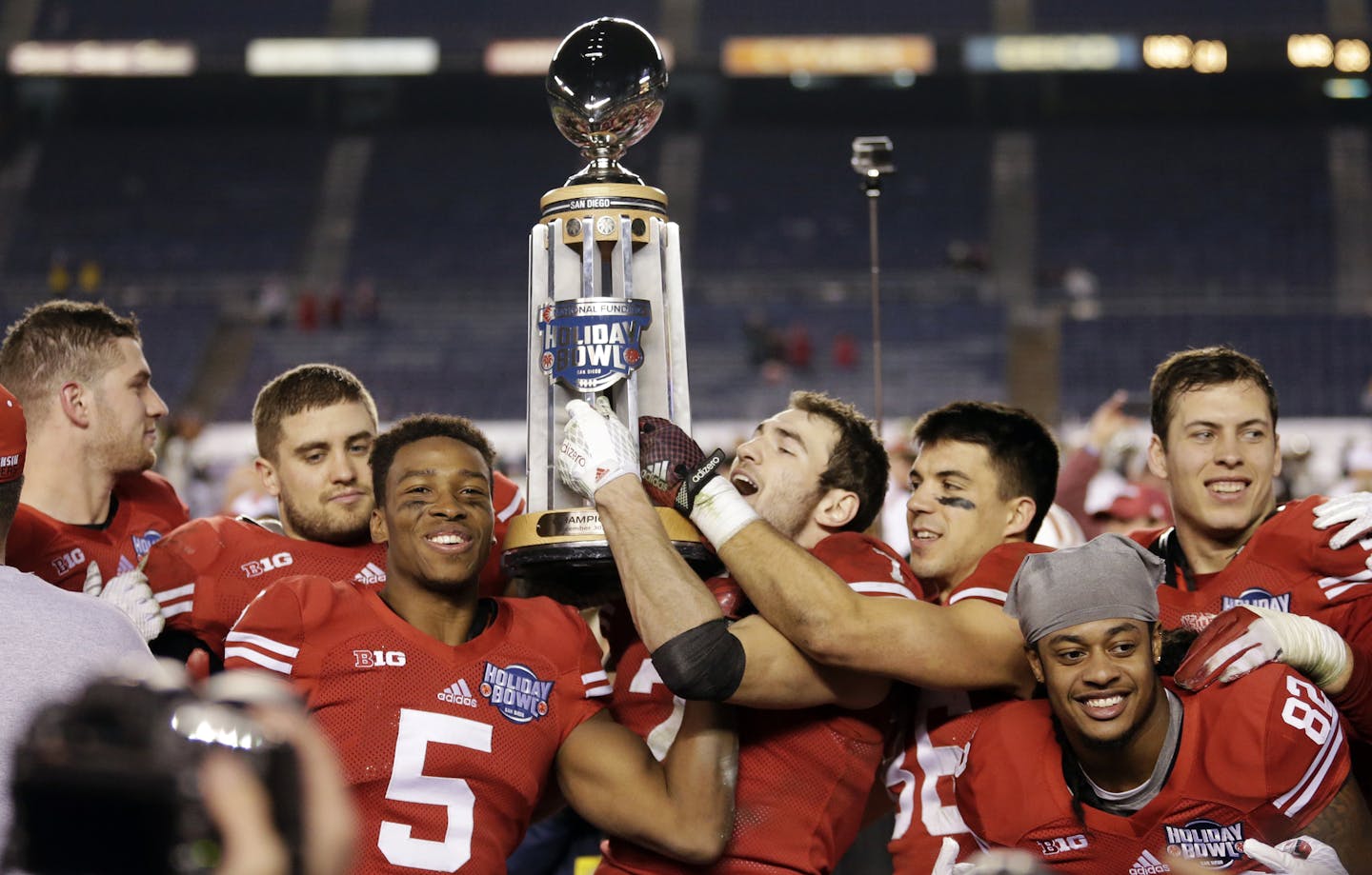 Wisconsin players hold the Holiday Bowl trophy after defeating Southern California in the Holiday Bowl NCAA college football game Wednesday, Dec. 30, 2015, in San Diego. Wisconsin won 23-21. (AP Photo/Gregory Bull)