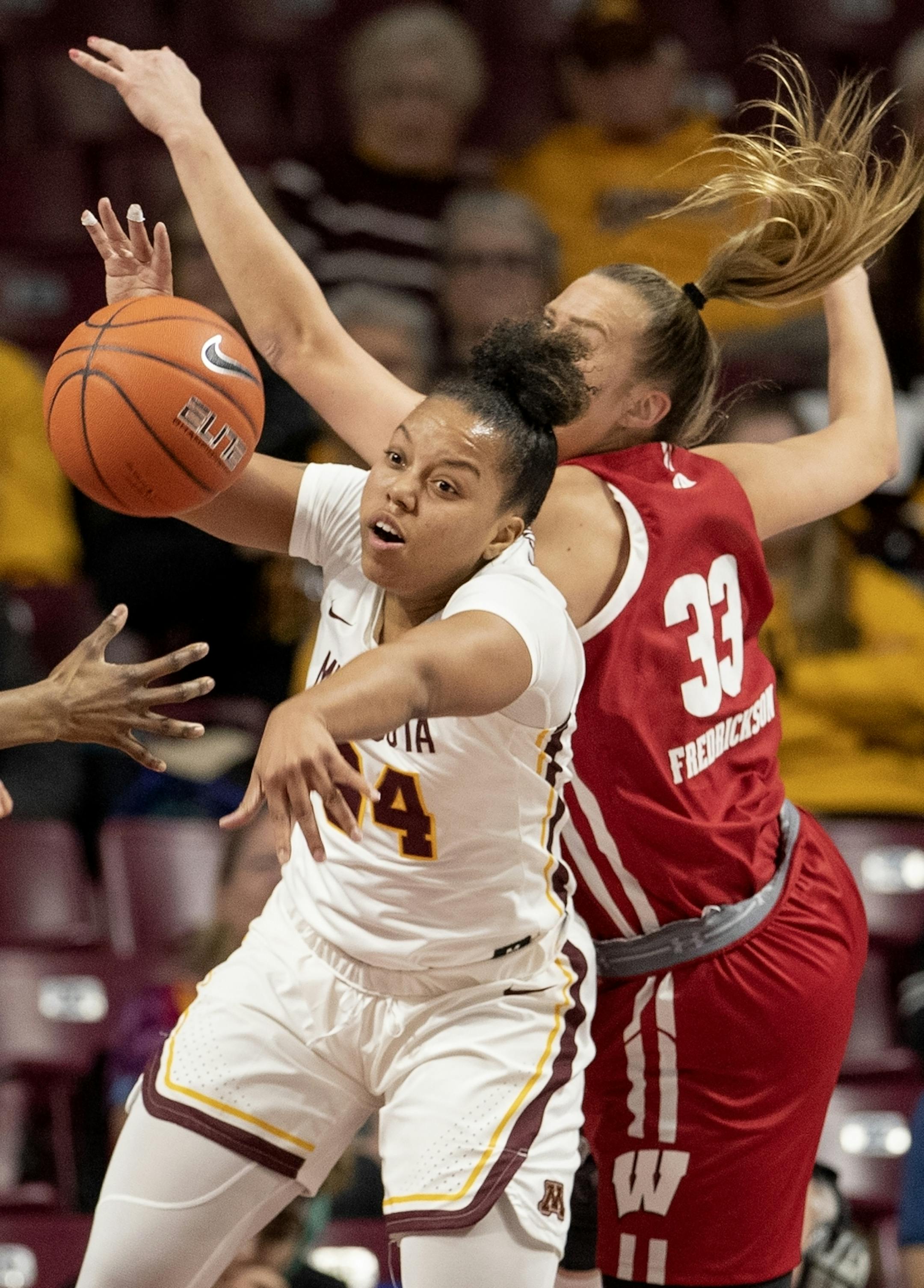 Gadiva Hubbard (34) of Minnesota and Courtney Fredrickson (33) of Wisconsin fought for a loose ball in the second quarter.