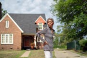 Muskegon County Commissioner Rillastine Wilkins in front of her Muskegon Heights home. Someone threw a brick through her front window when she moved i
