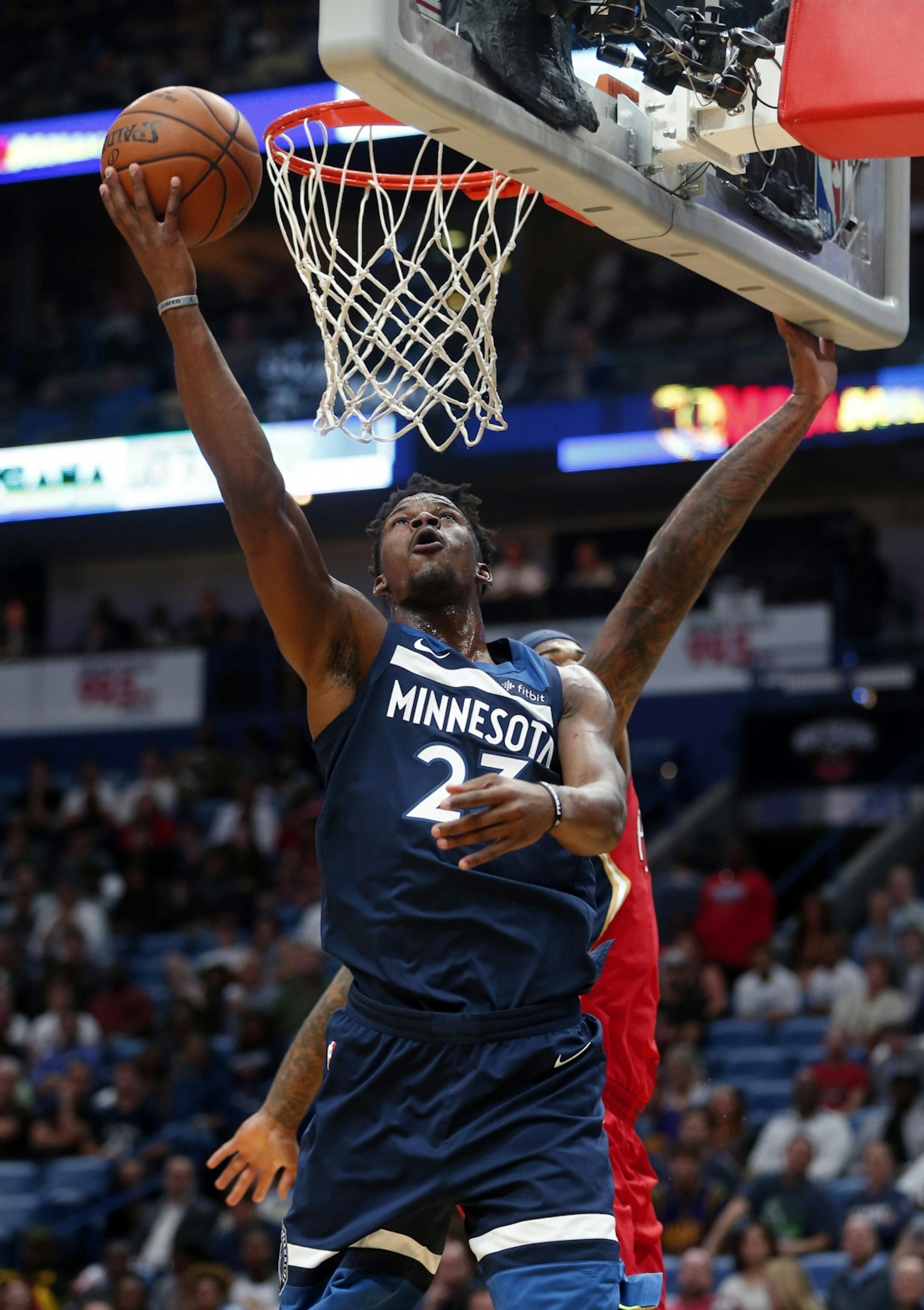 Minnesota Timberwolves guard Jimmy Butler (23) goes to the basket in front of New Orleans Pelicans center DeMarcus Cousins during the first half of an NBA basketball game in New Orleans, Wednesday, Nov. 29, 2017.