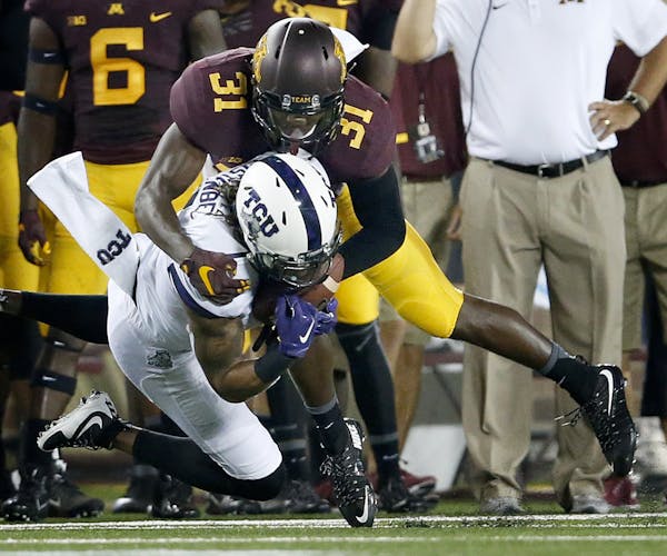 Gophers cornerback Eric Murray (31) tackled Kolby Listenbee of TCU in the first quarter Saturday.